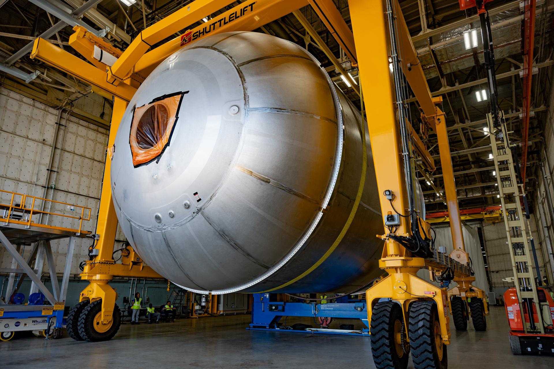 Teams at NASA’s Michoud Assembly Facility in New Orleans use a heavy-lift mobile transport apparatus to move a 51-foot-tall liquid oxygen tank out of the vertical assembly building and into the main rocket factory on June 11. The liquidoxygen tank will form part of the SLS (Space Launch System) rocket for NASA’s Artemis IV mission to the Moon. Next, technicians with Boeing, SLS core stage prime contractor, and NASA will perform dimensional inspections and install internal baffles on the propellant tank before the next phase of production. The propellant tank will hold more than 196,000 gallons of super-cooled liquid oxygen at launch and is one of five major elements that make up the 212-foot-tall SLS rocket stage. The core stage, along with its four RS-25 engines at its base, produces more than two million pounds of thrust to help launch NASA’s Orion spacecraft, ronauts, and supplies beyond Earth’s orbit and to the lunar surface for Artemis.