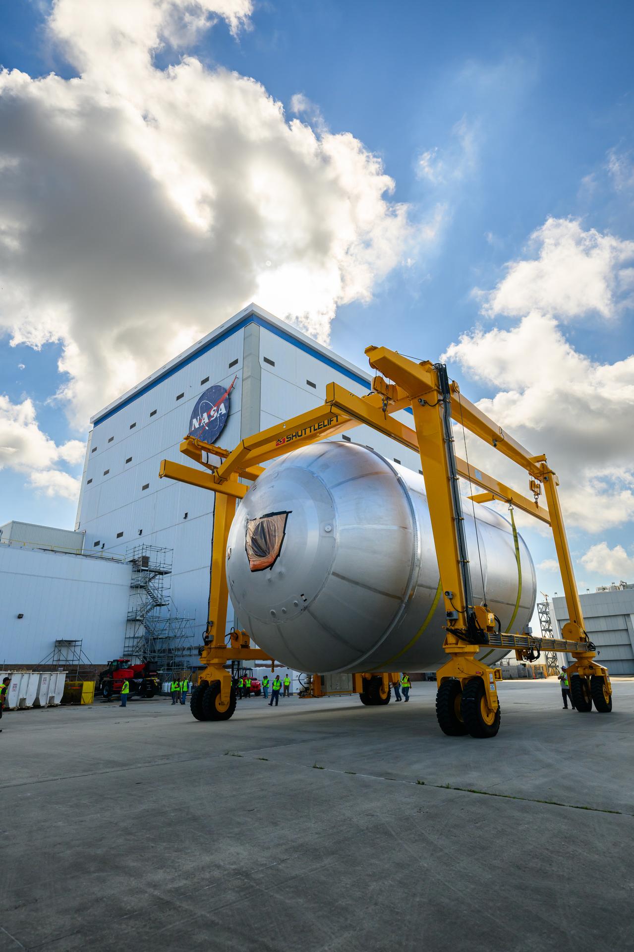 Teams at NASA’s Michoud Assembly Facility in New Orleans use a heavy-lift mobile transport apparatus to move a 51-foot-tall liquid oxygen tank out of the vertical assembly building and into the main rocket factory on June 11. The liquidoxygen tank will form part of the SLS (Space Launch System) rocket for NASA’s Artemis IV mission to the Moon. Next, technicians with Boeing, SLS core stage prime contractor, and NASA will perform dimensional inspections and install internal baffles on the propellant tank before the next phase of production. The propellant tank will hold more than 196,000 gallons of super-cooled liquid oxygen at launch and is one of five major elements that make up the 212-foot-tall SLS rocket stage. The core stage, along with its four RS-25 engines at its base, produces more than two million pounds of thrust to help launch NASA’s Orion spacecraft, ronauts, and supplies beyond Earth’s orbit and to the lunar surface for Artemis.