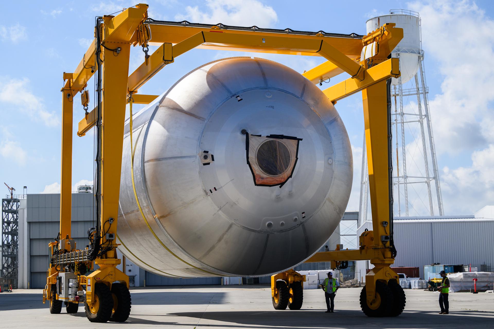Teams at NASA’s Michoud Assembly Facility in New Orleans use a heavy-lift mobile transport apparatus to move a 51-foot-tall liquid oxygen tank out of the vertical assembly building and into the main rocket factory on June 11. The liquidoxygen tank will form part of the SLS (Space Launch System) rocket for NASA’s Artemis IV mission to the Moon. Next, technicians with Boeing, SLS core stage prime contractor, and NASA will perform dimensional inspections and install internal baffles on the propellant tank before the next phase of production. The propellant tank will hold more than 196,000 gallons of super-cooled liquid oxygen at launch and is one of five major elements that make up the 212-foot-tall SLS rocket stage. The core stage, along with its four RS-25 engines at its base, produces more than two million pounds of thrust to help launch NASA’s Orion spacecraft, ronauts, and supplies beyond Earth’s orbit and to the lunar surface for Artemis.