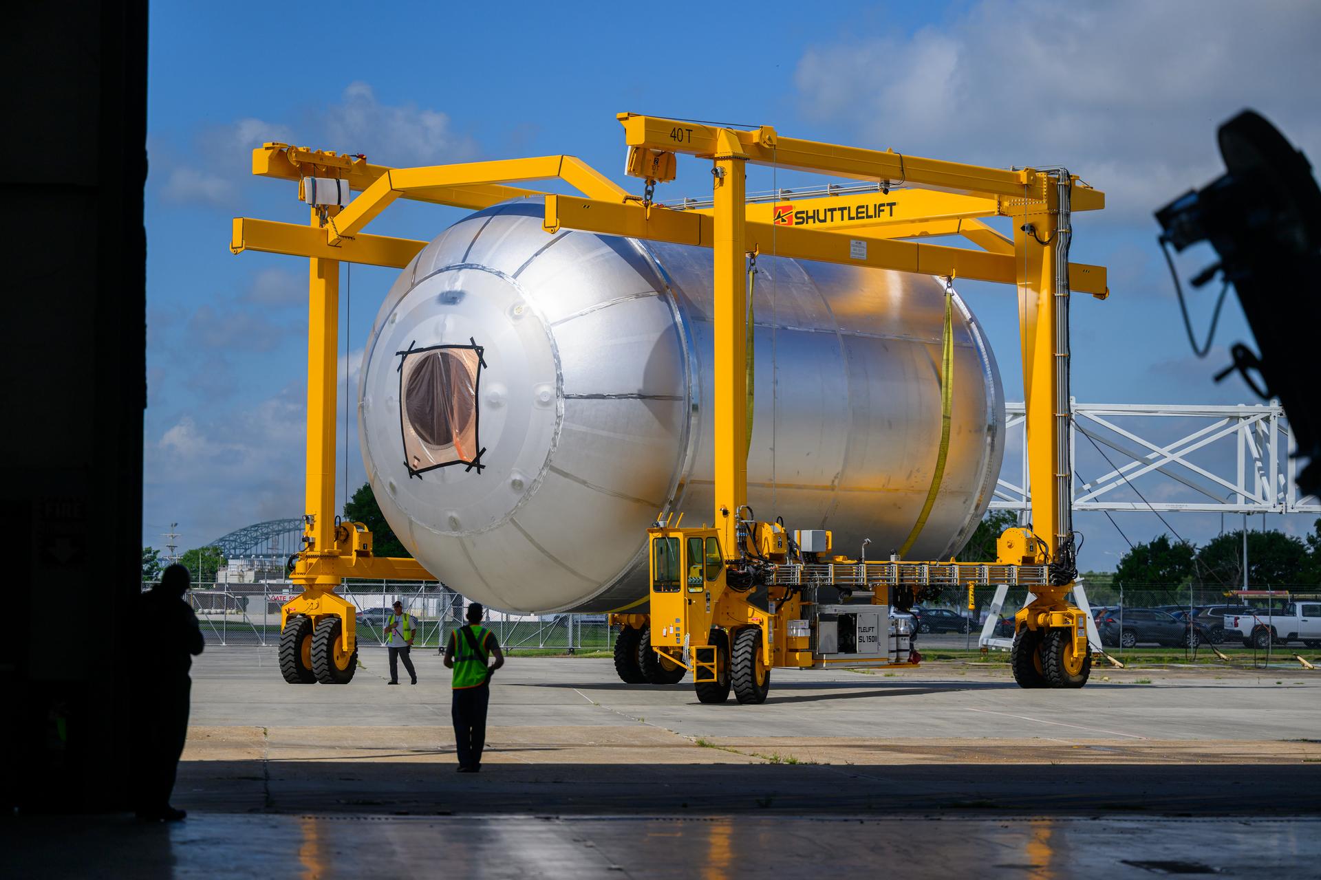 Teams at NASA’s Michoud Assembly Facility in New Orleans use a heavy-lift mobile transport apparatus to move a 51-foot-tall liquid oxygen tank out of the vertical assembly building and into the main rocket factory on June 11. The liquidoxygen tank will form part of the SLS (Space Launch System) rocket for NASA’s Artemis IV mission to the Moon. Next, technicians with Boeing, SLS core stage prime contractor, and NASA will perform dimensional inspections and install internal baffles on the propellant tank before the next phase of production. The propellant tank will hold more than 196,000 gallons of super-cooled liquid oxygen at launch and is one of five major elements that make up the 212-foot-tall SLS rocket stage. The core stage, along with its four RS-25 engines at its base, produces more than two million pounds of thrust to help launch NASA’s Orion spacecraft, ronauts, and supplies beyond Earth’s orbit and to the lunar surface for Artemis.