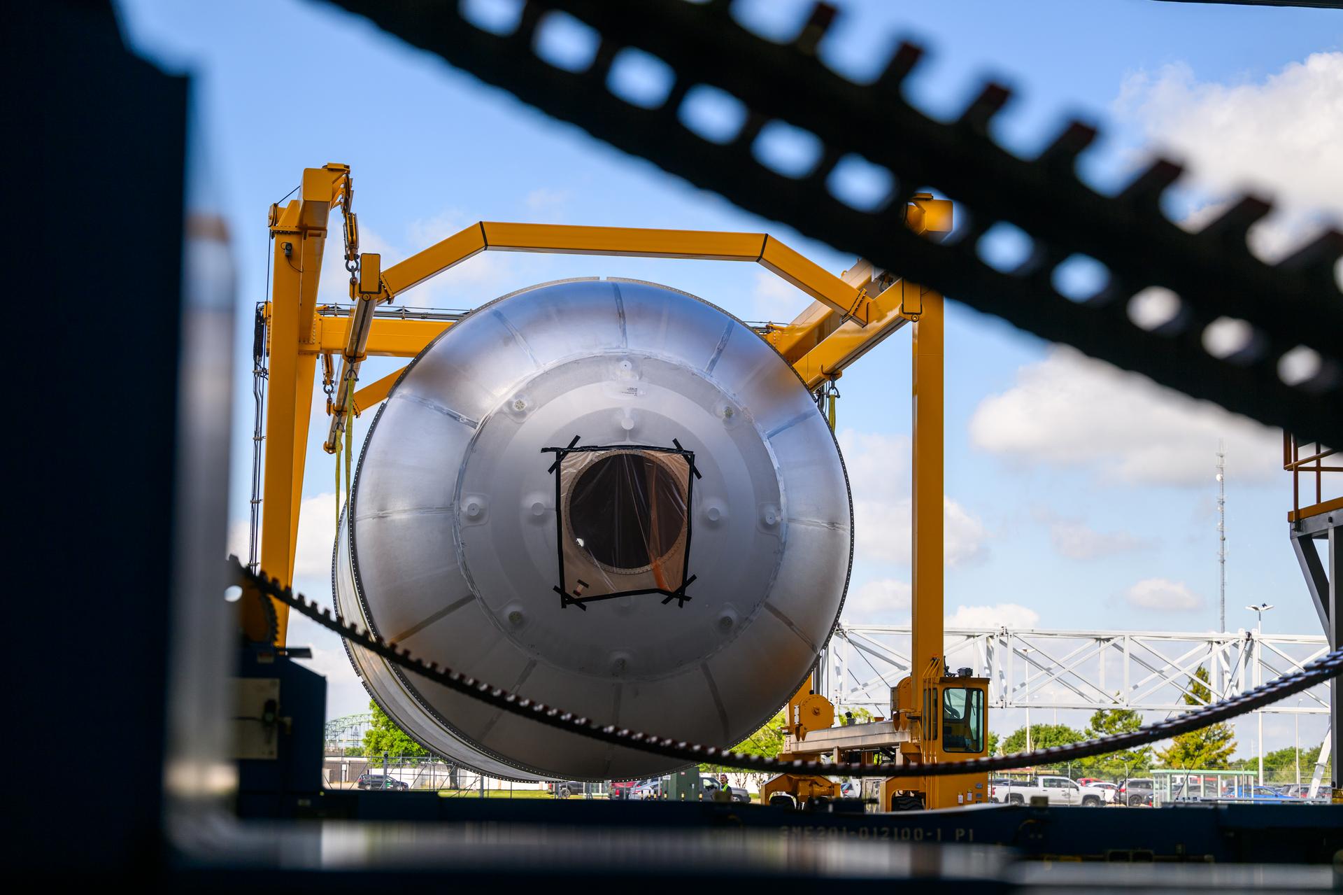 Teams at NASA’s Michoud Assembly Facility in New Orleans use a heavy-lift mobile transport apparatus to move a 51-foot-tall liquid oxygen tank out of the vertical assembly building and into the main rocket factory on June 11. The liquidoxygen tank will form part of the SLS (Space Launch System) rocket for NASA’s Artemis IV mission to the Moon. Next, technicians with Boeing, SLS core stage prime contractor, and NASA will perform dimensional inspections and install internal baffles on the propellant tank before the next phase of production. The propellant tank will hold more than 196,000 gallons of super-cooled liquid oxygen at launch and is one of five major elements that make up the 212-foot-tall SLS rocket stage. The core stage, along with its four RS-25 engines at its base, produces more than two million pounds of thrust to help launch NASA’s Orion spacecraft, ronauts, and supplies beyond Earth’s orbit and to the lunar surface for Artemis.
