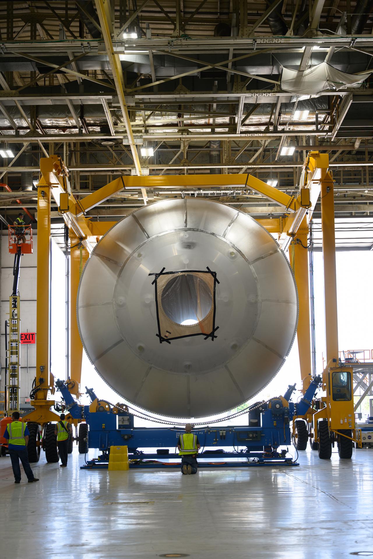 Teams at NASA’s Michoud Assembly Facility in New Orleans use a heavy-lift mobile transport apparatus to move a 51-foot-tall liquid oxygen tank out of the vertical assembly building and into the main rocket factory on June 11. The liquidoxygen tank will form part of the SLS (Space Launch System) rocket for NASA’s Artemis IV mission to the Moon. Next, technicians with Boeing, SLS core stage prime contractor, and NASA will perform dimensional inspections and install internal baffles on the propellant tank before the next phase of production. The propellant tank will hold more than 196,000 gallons of super-cooled liquid oxygen at launch and is one of five major elements that make up the 212-foot-tall SLS rocket stage. The core stage, along with its four RS-25 engines at its base, produces more than two million pounds of thrust to help launch NASA’s Orion spacecraft, ronauts, and supplies beyond Earth’s orbit and to the lunar surface for Artemis.
