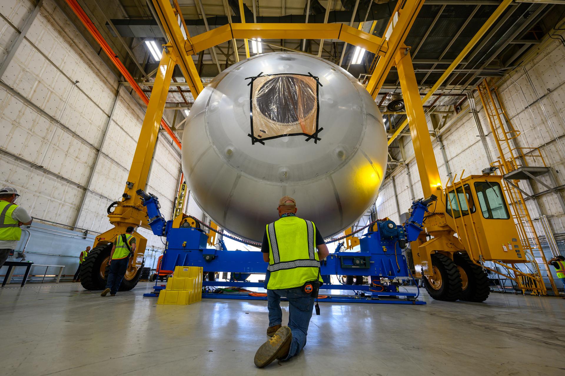 Teams at NASA’s Michoud Assembly Facility in New Orleans use a heavy-lift mobile transport apparatus to move a 51-foot-tall liquid oxygen tank out of the vertical assembly building and into the main rocket factory on June 11. The liquidoxygen tank will form part of the SLS (Space Launch System) rocket for NASA’s Artemis IV mission to the Moon. Next, technicians with Boeing, SLS core stage prime contractor, and NASA will perform dimensional inspections and install internal baffles on the propellant tank before the next phase of production. The propellant tank will hold more than 196,000 gallons of super-cooled liquid oxygen at launch and is one of five major elements that make up the 212-foot-tall SLS rocket stage. The core stage, along with its four RS-25 engines at its base, produces more than two million pounds of thrust to help launch NASA’s Orion spacecraft, ronauts, and supplies beyond Earth’s orbit and to the lunar surface for Artemis.