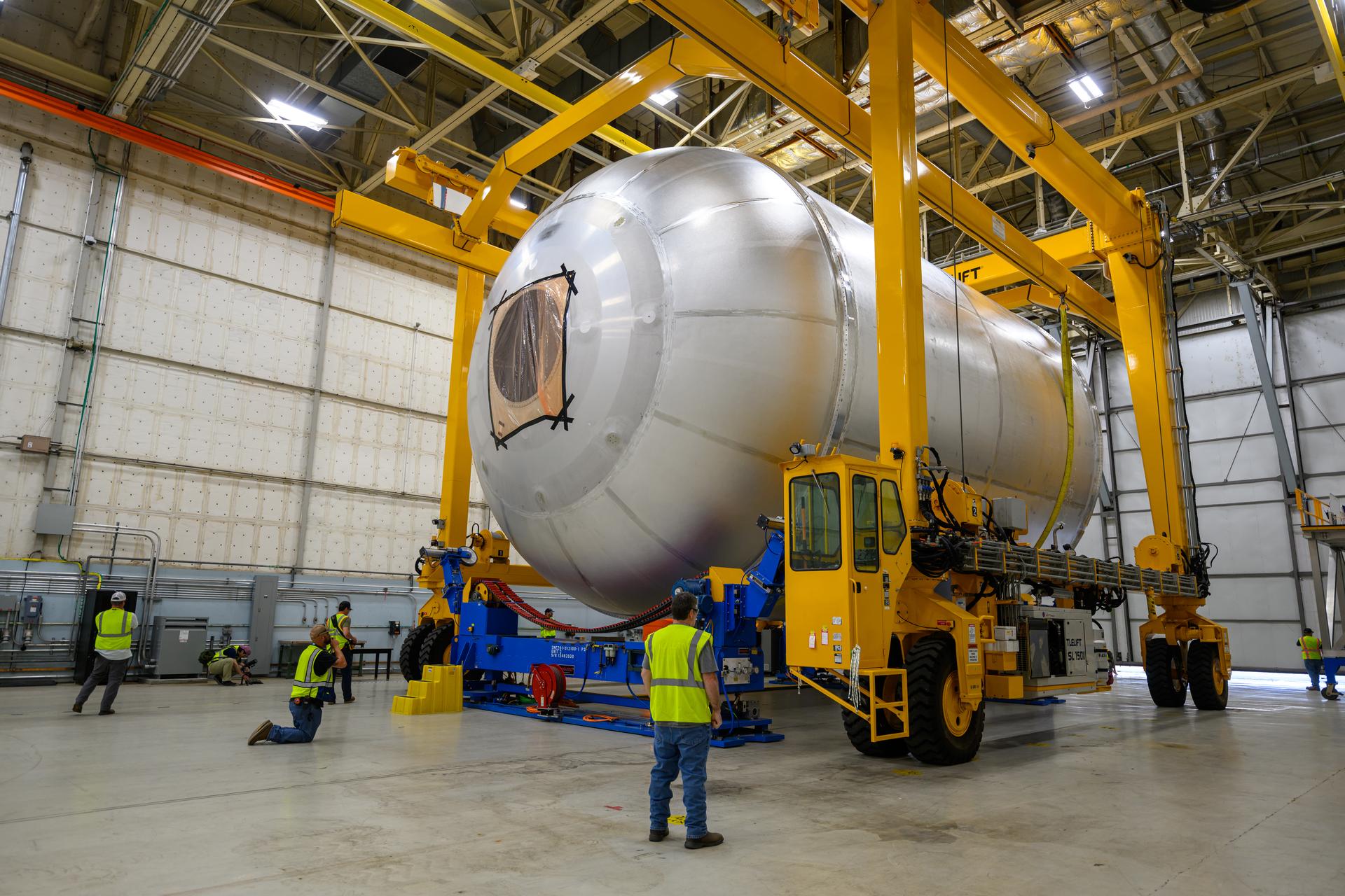 Teams at NASA’s Michoud Assembly Facility in New Orleans use a heavy-lift mobile transport apparatus to move a 51-foot-tall liquid oxygen tank out of the vertical assembly building and into the main rocket factory on June 11. The liquidoxygen tank will form part of the SLS (Space Launch System) rocket for NASA’s Artemis IV mission to the Moon. Next, technicians with Boeing, SLS core stage prime contractor, and NASA will perform dimensional inspections and install internal baffles on the propellant tank before the next phase of production. The propellant tank will hold more than 196,000 gallons of super-cooled liquid oxygen at launch and is one of five major elements that make up the 212-foot-tall SLS rocket stage. The core stage, along with its four RS-25 engines at its base, produces more than two million pounds of thrust to help launch NASA’s Orion spacecraft, ronauts, and supplies beyond Earth’s orbit and to the lunar surface for Artemis.