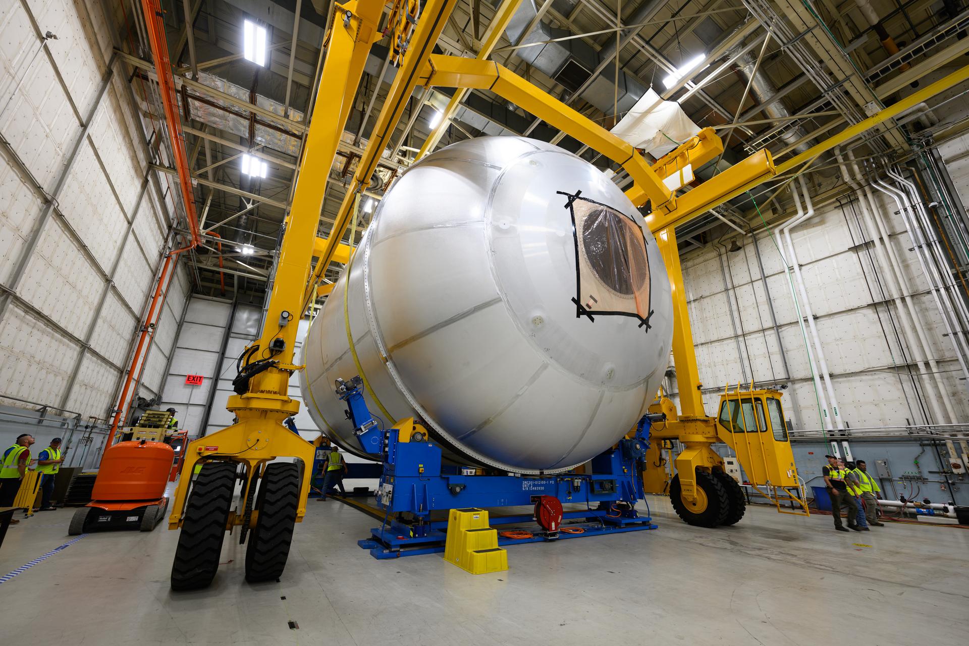 Teams at NASA’s Michoud Assembly Facility in New Orleans use a heavy-lift mobile transport apparatus to move a 51-foot-tall liquid oxygen tank out of the vertical assembly building and into the main rocket factory on June 11. The liquidoxygen tank will form part of the SLS (Space Launch System) rocket for NASA’s Artemis IV mission to the Moon. Next, technicians with Boeing, SLS core stage prime contractor, and NASA will perform dimensional inspections and install internal baffles on the propellant tank before the next phase of production. The propellant tank will hold more than 196,000 gallons of super-cooled liquid oxygen at launch and is one of five major elements that make up the 212-foot-tall SLS rocket stage. The core stage, along with its four RS-25 engines at its base, produces more than two million pounds of thrust to help launch NASA’s Orion spacecraft, ronauts, and supplies beyond Earth’s orbit and to the lunar surface for Artemis.