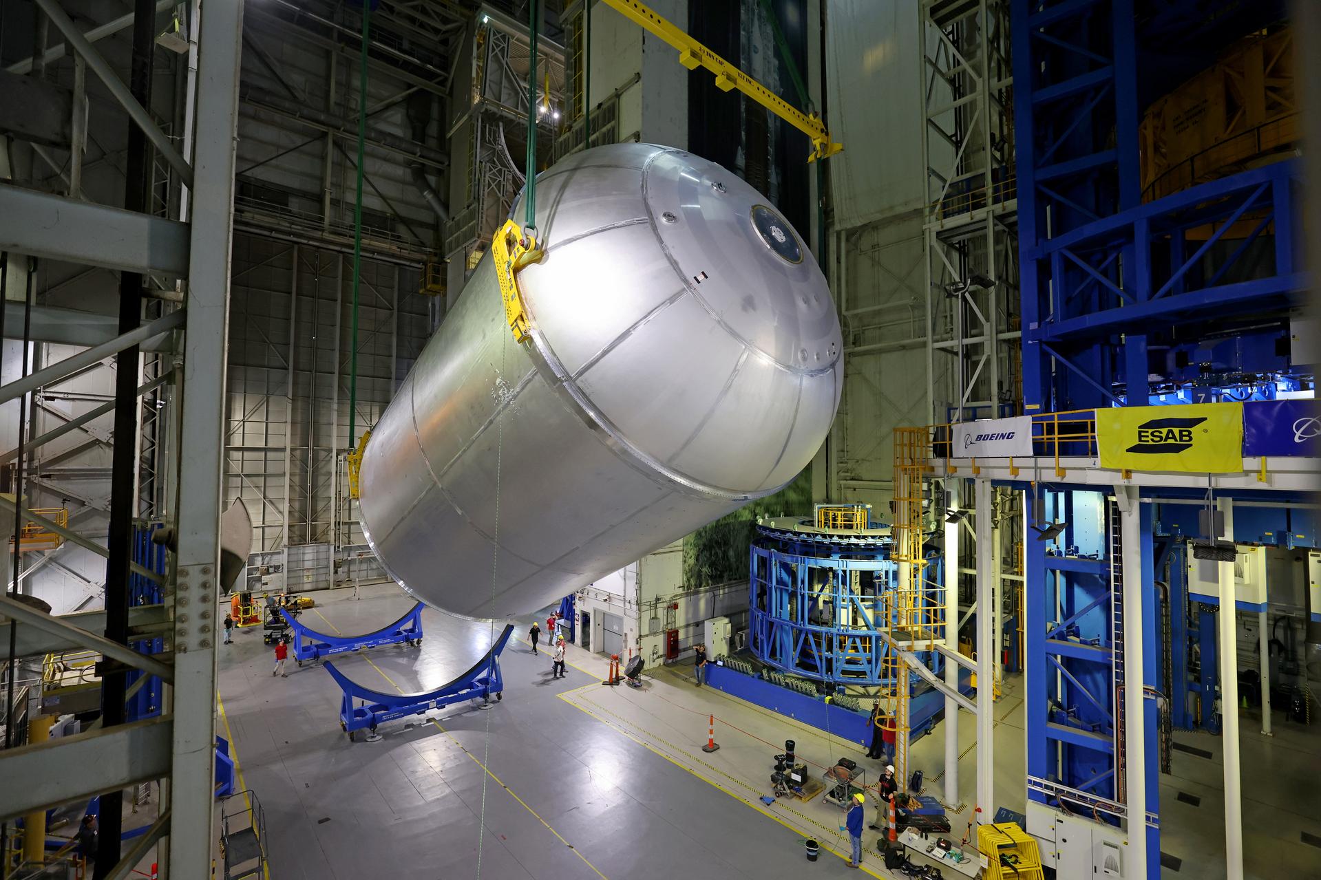 Teams at NASA’s Michoud Assembly Facility in New Orleans move a liquid oxygen tank from the main rocket factory into the adjacent vertical assembly building. The liquid oxygen tank, which will form part of the SLS (Space Launch System) rocket for NASA’s Artemis IV mission to the Moon, is rotated from a horizontal to a vertical configuration and loaded into the high bay’s hydrostatic proof testing cell. This non-destructive evaluation method tests the structural integrity of the tank’s welds by filling the tank with water, simulating the propellant used during launch. The propellant tank will hold more than 196,000 gallons of super-cooled liquid oxygen at launch and is one of five major elements that make up the 212-foot-tall SLS rocket stage. The core stage, along with its four RS-25 engines at its base, produces more than two million pounds of thrust to help launch NASA’s Orion spacecraft, astronauts, and supplies beyond Earth’s orbit and to the lunar surface for Artemis. Image credit: NASA/Michael DeMocker
