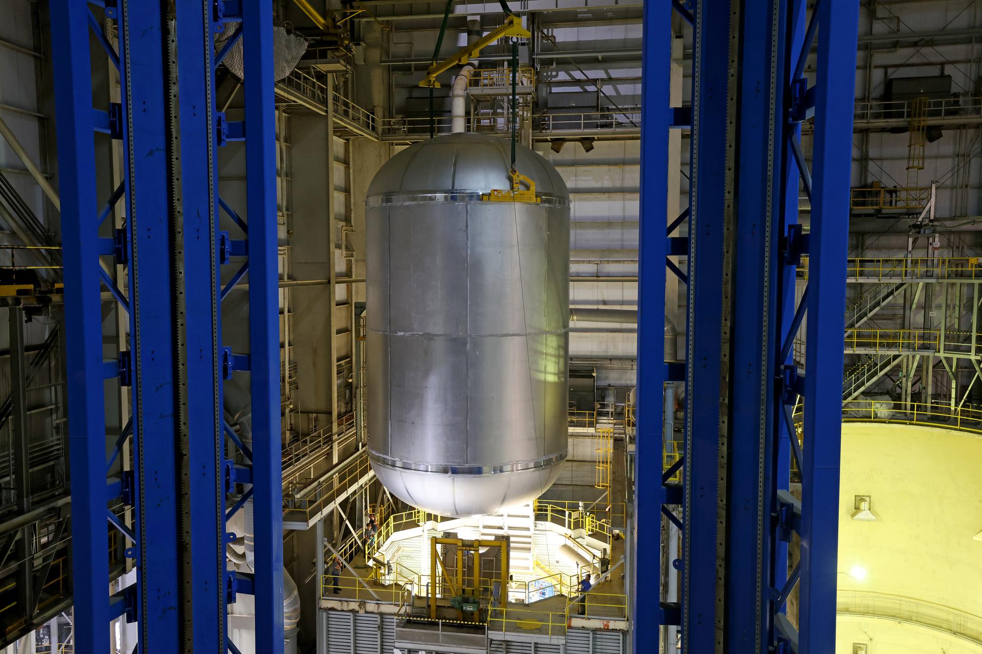 Teams at NASA’s Michoud Assembly Facility in New Orleans move a liquid oxygen tank from the main rocket factory into the adjacent vertical assembly building. The liquid oxygen tank, which will form part of the SLS (Space Launch System) rocket for NASA’s Artemis IV mission to the Moon, is rotated from a horizontal to a vertical configuration and loaded into the high bay’s hydrostatic proof testing cell. This non-destructive evaluation method tests the structural integrity of the tank’s welds by filling the tank with water, simulating the propellant used during launch. The propellant tank will hold more than 196,000 gallons of super-cooled liquid oxygen at launch and is one of five major elements that make up the 212-foot-tall SLS rocket stage. The core stage, along with its four RS-25 engines at its base, produces more than two million pounds of thrust to help launch NASA’s Orion spacecraft, astronauts, and supplies beyond Earth’s orbit and to the lunar surface for Artemis. Image credit: NASA/Michael DeMocker