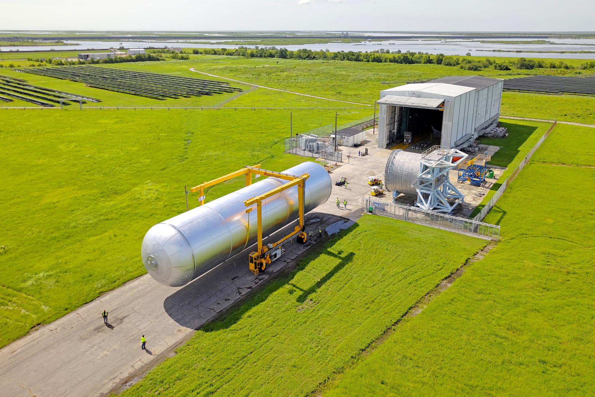 Crews at NASA’s Michoud Assembly Facility in New Orleans transport the 130-foot-tall liquid hydrogen tank from the proof testing building to the main factory on July 10. The liquid hydrogen tank will form part of the core stage for the SLS (Space Launch System) rocket for the agency’s Artemis IV mission, providing thousands of gallons of super-cold propellant to the rocket engines during launch. Soon, teams with SLS prime contractor, Boeing, will move the tank into the facility’s vertical assembly building for cleaning operations. The liquid hydrogen propellant tank is one of five major elements that make up the 212-foot-tall SLS rocket stage. The core stage, along with its four RS-25 engines at its base, produce more than two million pounds of thrust to help launch NASA’s Orion spacecraft, astronauts, and supplies beyond Earth’s orbit and to the lunar surface for Artemis. Image credit: NASA/Eric Bordelon & Michael DeMocker