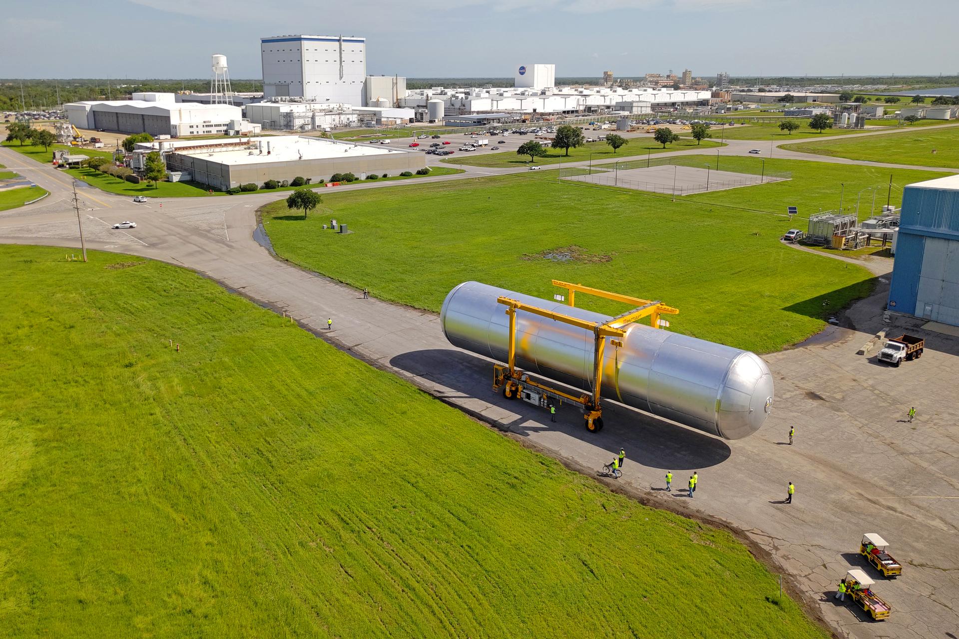 Crews at NASA’s Michoud Assembly Facility in New Orleans transport the 130-foot-tall liquid hydrogen tank from the proof testing building to the main factory on July 10. The liquid hydrogen tank will form part of the core stage for the SLS (Space Launch System) rocket for the agency’s Artemis IV mission, providing thousands of gallons of super-cold propellant to the rocket engines during launch. Soon, teams with SLS prime contractor, Boeing, will move the tank into the facility’s vertical assembly building for cleaning operations. The liquid hydrogen propellant tank is one of five major elements that make up the 212-foot-tall SLS rocket stage. The core stage, along with its four RS-25 engines at its base, produce more than two million pounds of thrust to help launch NASA’s Orion spacecraft, astronauts, and supplies beyond Earth’s orbit and to the lunar surface for Artemis. Image credit: NASA/Eric Bordelon & Michael DeMocker