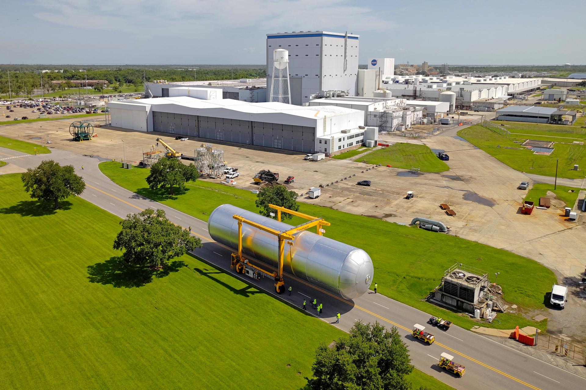 Crews at NASA’s Michoud Assembly Facility in New Orleans transport the 130-foot-tall liquid hydrogen tank from the proof testing building to the main factory on July 10. The liquid hydrogen tank will form part of the core stage for the SLS (Space Launch System) rocket for the agency’s Artemis IV mission, providing thousands of gallons of super-cold propellant to the rocket engines during launch. Soon, teams with SLS prime contractor, Boeing, will move the tank into the facility’s vertical assembly building for cleaning operations. The liquid hydrogen propellant tank is one of five major elements that make up the 212-foot-tall SLS rocket stage. The core stage, along with its four RS-25 engines at its base, produce more than two million pounds of thrust to help launch NASA’s Orion spacecraft, astronauts, and supplies beyond Earth’s orbit and to the lunar surface for Artemis. Image credit: NASA/Eric Bordelon & Michael DeMocker