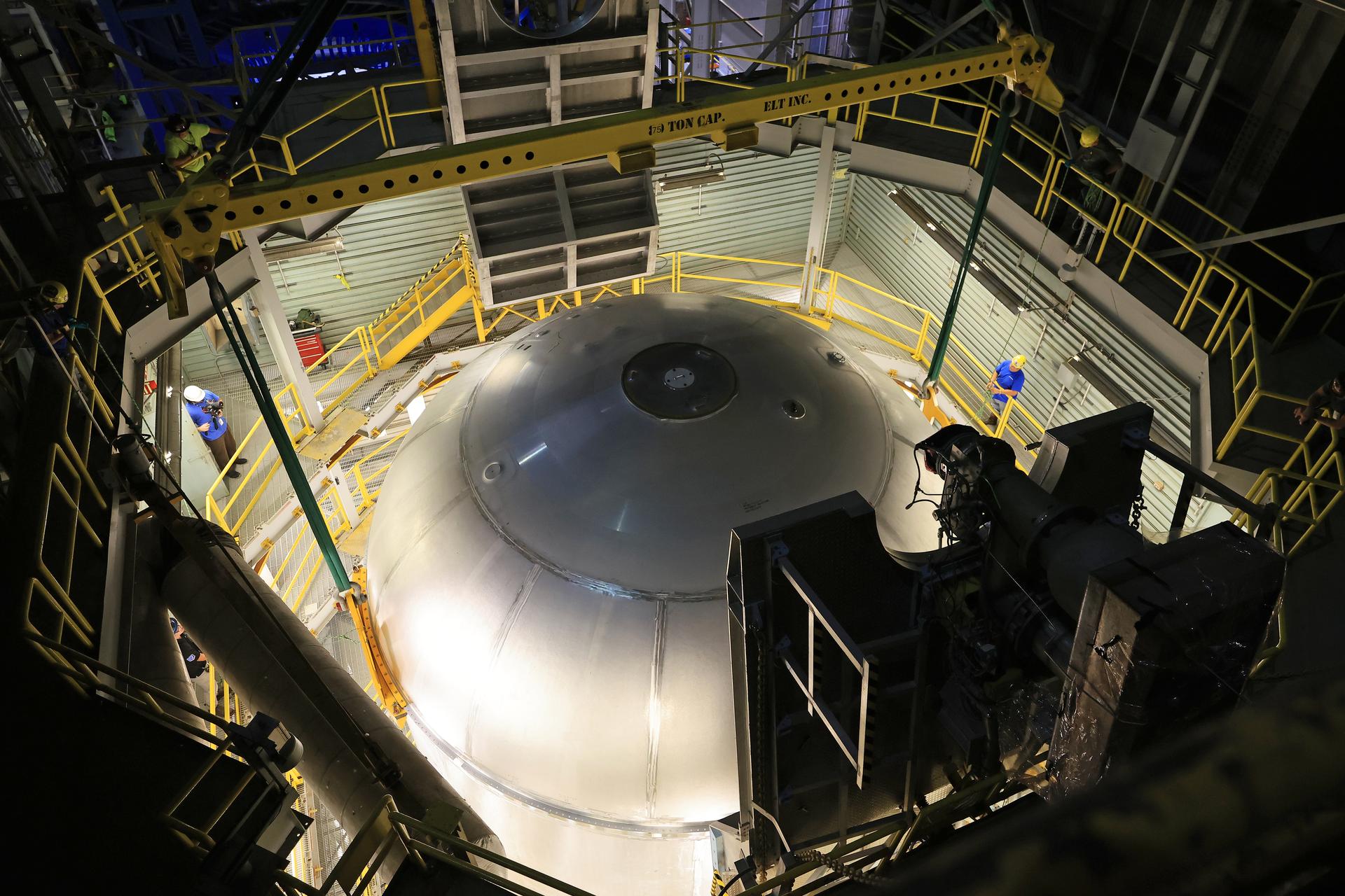 Teams at NASA’s Michoud Assembly Facility in New Orleans lift a 51-foot-tall liquid oxygen tank out of the high bay’s hydrostatic proof testing cell on July 20, 2026. The liquid oxygen tank, which will form part of the SLS (Space Launch System) rocket for NASA’s Artemis IV mission to the Moon, is rotated from a vertical to a horizontal configuration and placed into two static cradles in the main aisle of the vertical assembly building. Having completed proof testing, teams prepare the tank for transport to a production area in the main factory where they will perform post-proof non-destructive evaluations. The propellant tank will hold more than 196,000 gallons of super-cooled liquid oxygen at launch and is one of five major elements that make up the 212-foot-tall SLS rocket stage. The core stage, along with its four RS-25 engines at its base, produces more than two million pounds of thrust to help launch NASA’s Orion spacecraft, astronauts, and supplies beyond Earth’s orbit and to the lunar surface for Artemis. Image credit: NASA/Michael DeMocker