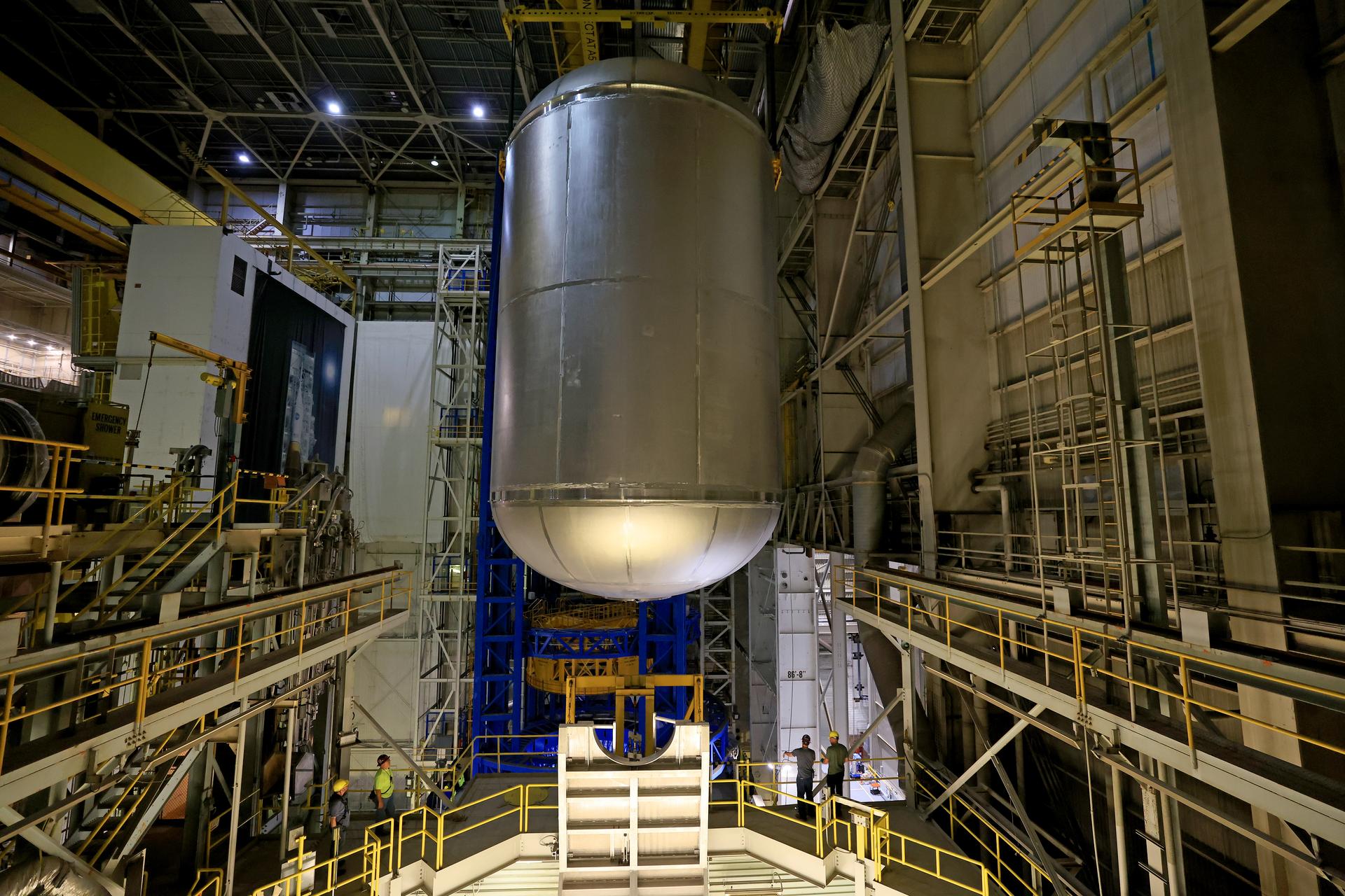 Teams at NASA’s Michoud Assembly Facility in New Orleans lift a 51-foot-tall liquid oxygen tank out of the high bay’s hydrostatic proof testing cell on July 20, 2026. The liquid oxygen tank, which will form part of the SLS (Space Launch System) rocket for NASA’s Artemis IV mission to the Moon, is rotated from a vertical to a horizontal configuration and placed into two static cradles in the main aisle of the vertical assembly building. Having completed proof testing, teams prepare the tank for transport to a production area in the main factory where they will perform post-proof non-destructive evaluations. The propellant tank will hold more than 196,000 gallons of super-cooled liquid oxygen at launch and is one of five major elements that make up the 212-foot-tall SLS rocket stage. The core stage, along with its four RS-25 engines at its base, produces more than two million pounds of thrust to help launch NASA’s Orion spacecraft, astronauts, and supplies beyond Earth’s orbit and to the lunar surface for Artemis. Image credit: NASA/Michael DeMocker