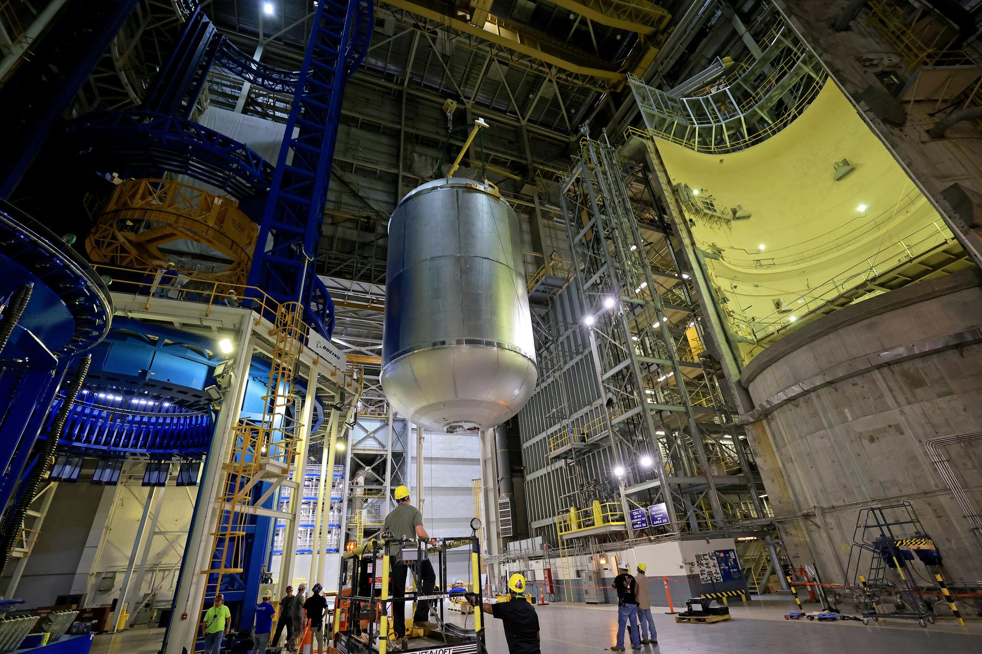Teams at NASA’s Michoud Assembly Facility in New Orleans lift a 51-foot-tall liquid oxygen tank out of the high bay’s hydrostatic proof testing cell on July 20, 2026. The liquid oxygen tank, which will form part of the SLS (Space Launch System) rocket for NASA’s Artemis IV mission to the Moon, is rotated from a vertical to a horizontal configuration and placed into two static cradles in the main aisle of the vertical assembly building. Having completed proof testing, teams prepare the tank for transport to a production area in the main factory where they will perform post-proof non-destructive evaluations. The propellant tank will hold more than 196,000 gallons of super-cooled liquid oxygen at launch and is one of five major elements that make up the 212-foot-tall SLS rocket stage. The core stage, along with its four RS-25 engines at its base, produces more than two million pounds of thrust to help launch NASA’s Orion spacecraft, astronauts, and supplies beyond Earth’s orbit and to the lunar surface for Artemis. Image credit: NASA/Michael DeMocker