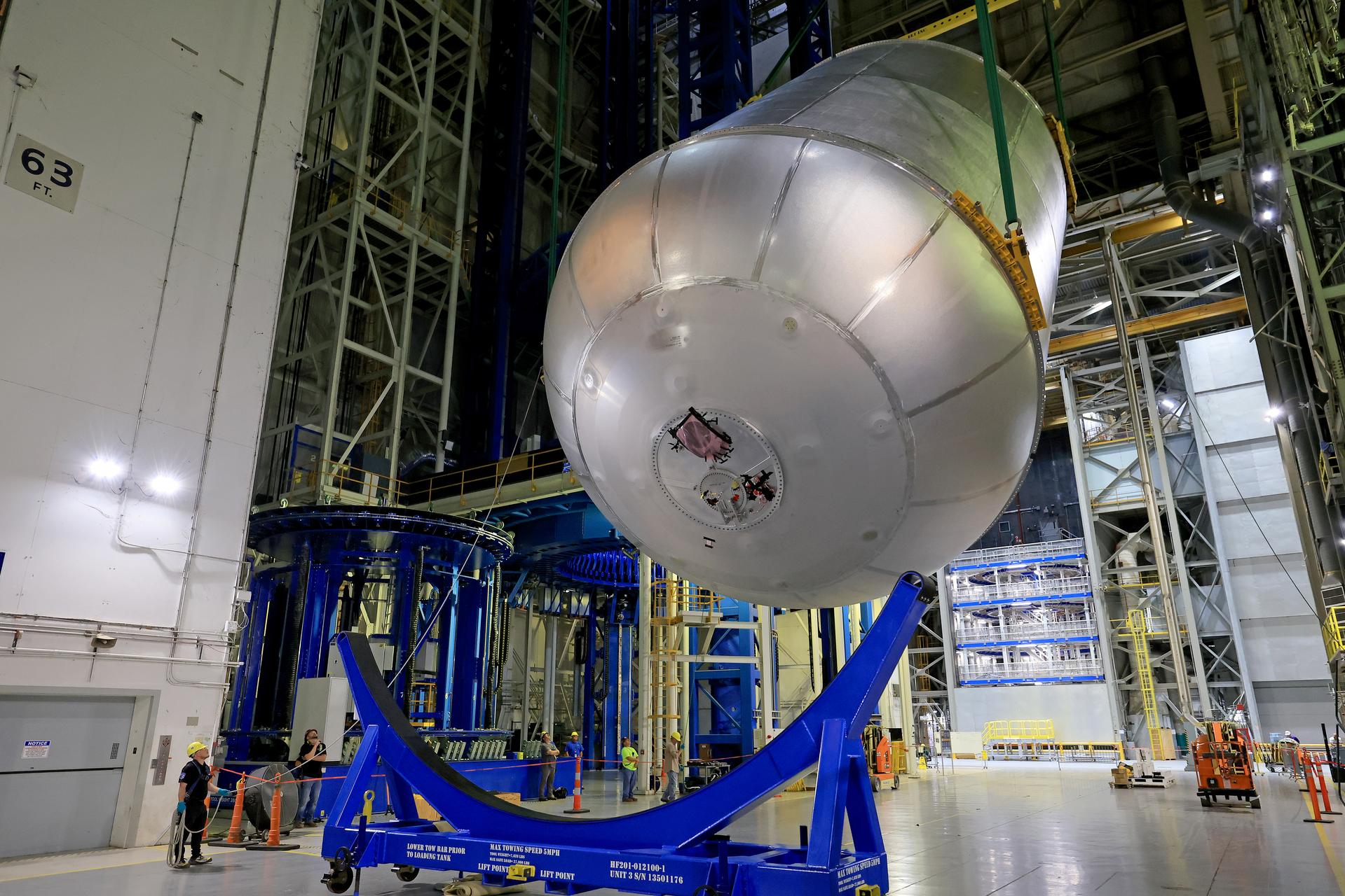 Teams at NASA’s Michoud Assembly Facility in New Orleans lift a 51-foot-tall liquid oxygen tank out of the high bay’s hydrostatic proof testing cell on July 20, 2026. The liquid oxygen tank, which will form part of the SLS (Space Launch System) rocket for NASA’s Artemis IV mission to the Moon, is rotated from a vertical to a horizontal configuration and placed into two static cradles in the main aisle of the vertical assembly building. Having completed proof testing, teams prepare the tank for transport to a production area in the main factory where they will perform post-proof non-destructive evaluations. The propellant tank will hold more than 196,000 gallons of super-cooled liquid oxygen at launch and is one of five major elements that make up the 212-foot-tall SLS rocket stage. The core stage, along with its four RS-25 engines at its base, produces more than two million pounds of thrust to help launch NASA’s Orion spacecraft, astronauts, and supplies beyond Earth’s orbit and to the lunar surface for Artemis. Image credit: NASA/Michael DeMocker