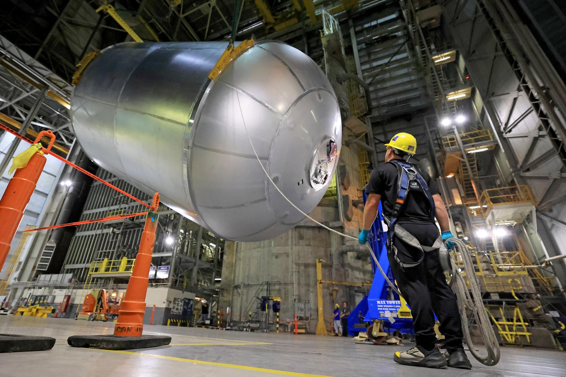 Teams at NASA’s Michoud Assembly Facility in New Orleans lift a 51-foot-tall liquid oxygen tank out of the high bay’s hydrostatic proof testing cell on July 20, 2026. The liquid oxygen tank, which will form part of the SLS (Space Launch System) rocket for NASA’s Artemis IV mission to the Moon, is rotated from a vertical to a horizontal configuration and placed into two static cradles in the main aisle of the vertical assembly building. Having completed proof testing, teams prepare the tank for transport to a production area in the main factory where they will perform post-proof non-destructive evaluations. The propellant tank will hold more than 196,000 gallons of super-cooled liquid oxygen at launch and is one of five major elements that make up the 212-foot-tall SLS rocket stage. The core stage, along with its four RS-25 engines at its base, produces more than two million pounds of thrust to help launch NASA’s Orion spacecraft, astronauts, and supplies beyond Earth’s orbit and to the lunar surface for Artemis. Image credit: NASA/Michael DeMocker