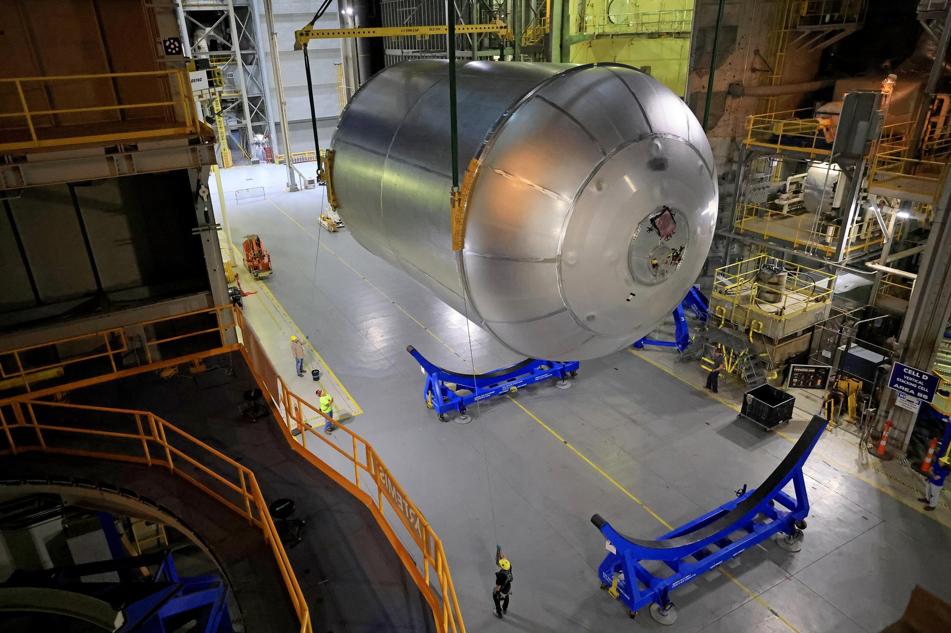 Teams at NASA’s Michoud Assembly Facility in New Orleans lift a 51-foot-tall liquid oxygen tank out of the high bay’s hydrostatic proof testing cell on July 20, 2026. The liquid oxygen tank, which will form part of the SLS (Space Launch System) rocket for NASA’s Artemis IV mission to the Moon, is rotated from a vertical to a horizontal configuration and placed into two static cradles in the main aisle of the vertical assembly building. Having completed proof testing, teams prepare the tank for transport to a production area in the main factory where they will perform post-proof non-destructive evaluations. The propellant tank will hold more than 196,000 gallons of super-cooled liquid oxygen at launch and is one of five major elements that make up the 212-foot-tall SLS rocket stage. The core stage, along with its four RS-25 engines at its base, produces more than two million pounds of thrust to help launch NASA’s Orion spacecraft, astronauts, and supplies beyond Earth’s orbit and to the lunar surface for Artemis. Image credit: NASA/Michael DeMocker