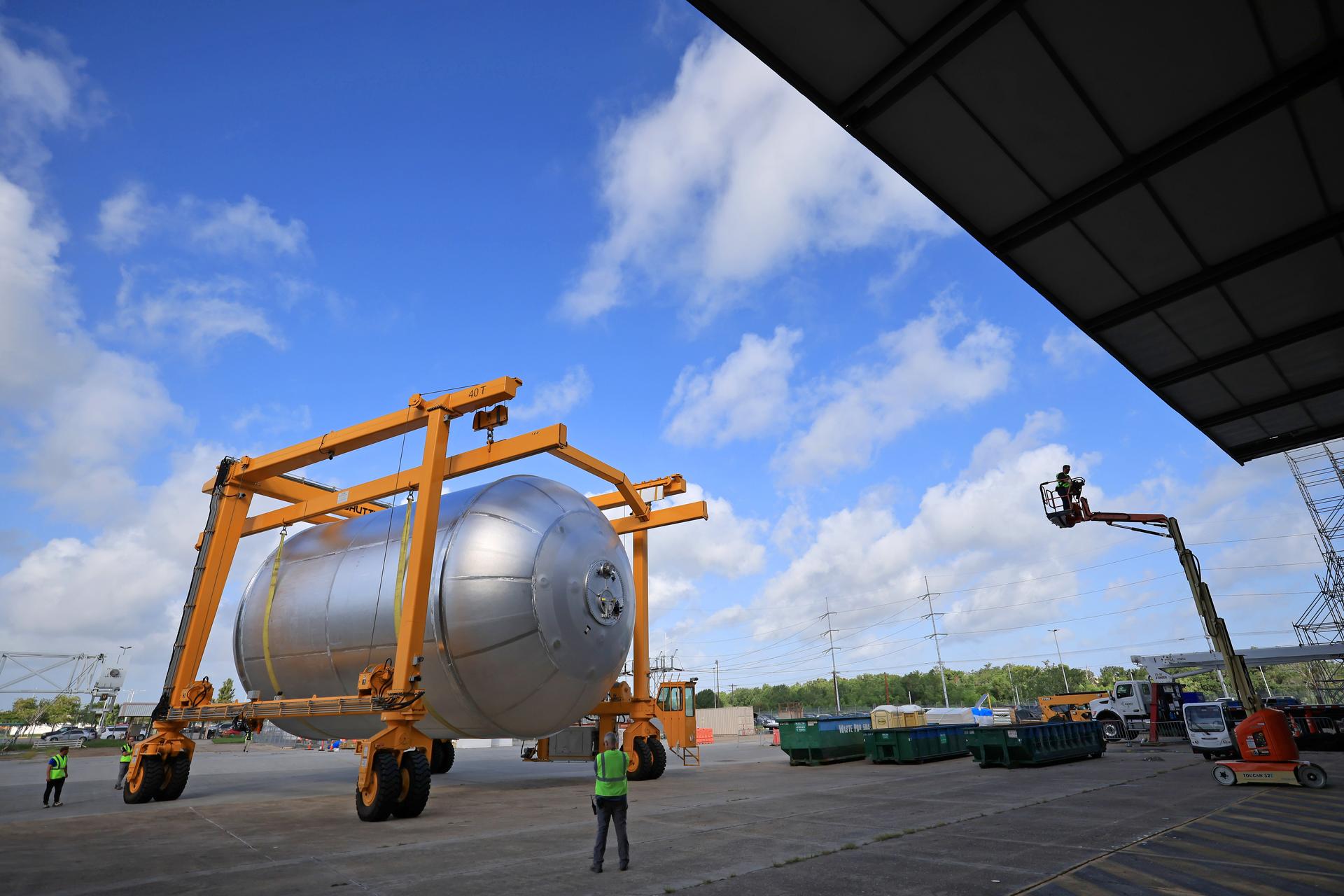 Teams at NASA’s Michoud Assembly Facility in New Orleans transport a 51-foot-tall liquid oxygen tank out of the vertical assembly building on July 23, 2026. The liquid oxygen tank, which will form part of the SLS (Space Launch System) rocket for NASA’s Artemis IV mission to the Moon, is suspended in a strap carrier transport apparatus and brought into the main factory building. Here, teams with SLS core stage prime contractor, Boeing, will perform post-proof non-destructive evaluations on the flight hardware before moving forward with tank cleaning. The propellant tank will hold more than 196,000 gallons of super-cooled liquid oxygen at launch and is one of five major elements that make up the 212-foot-tall SLS rocket stage. The core stage, along with its four RS-25 engines at its base, produces more than two million pounds of thrust to help launch NASA’s Orion spacecraft, astronauts, and supplies beyond Earth’s orbit and to the lunar surface for Artemis.  Image credit: NASA/Michael DeMocker