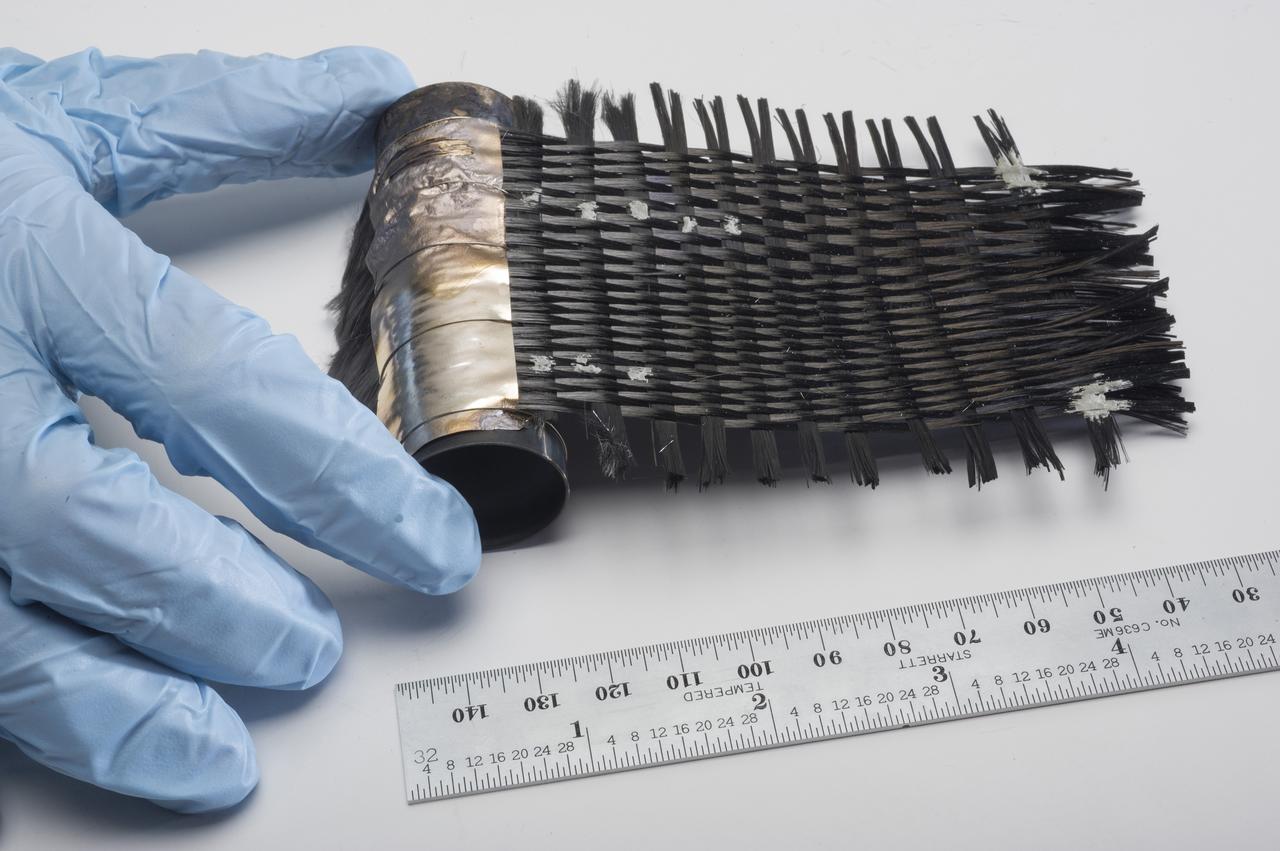 HAND-WOVEN MITSUBISHI K13D2U PITCH-BASED CARBON FIBERS BRAZED TO AN INCONEL TUBE.