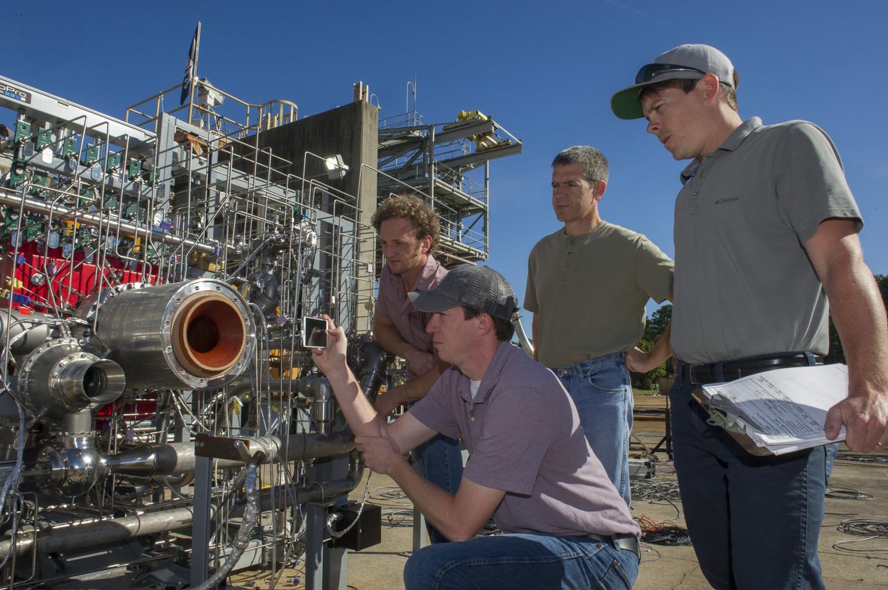 ASSEMBLING AND TESTING A BREADBOARD ENGINE MADE UP OF 3-D ENGINE COMPONENTS, PROPULSION ENGINEER NICK CASE (LEFT FRONT) PHOTOGRAPHS THE INJECTOR, WHILE RYAN WALLS (FAR RIGHT), THE TEST CONDUCTOR LOOKS ON. MARTY CALVERT (LEFT BACK) AND BRAD BULLARD (RIGHT BACK) HELPED DESIGN THE TURBOPUMP AND INJECTOR, TWO OF THE MOST COMPLEX ENGINE PARTS TESTED.