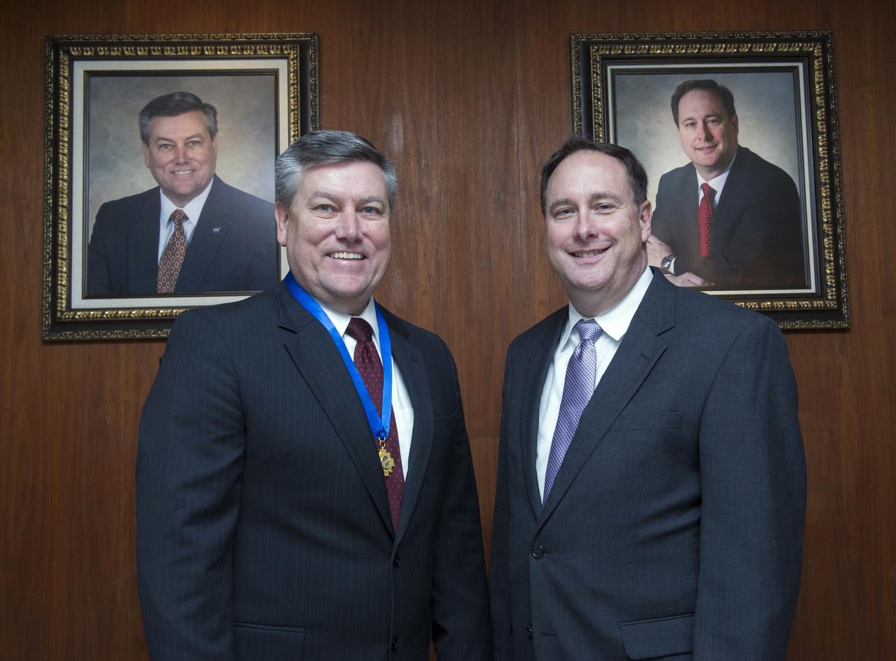 Former MSFC directors Patrick Scheuermann and Robert Lightfoot pose with their official photographic portraits hanging in Morris Auditorium