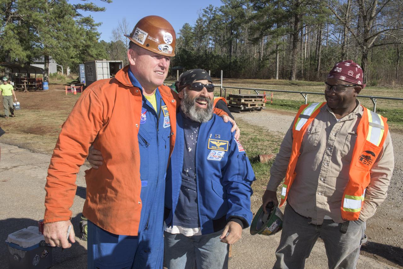 NASA astronaut Butch Wilmore exchanges jacket and hard hat with one of the construction workers building SLS test stand 4693 in the West test area of the Marshall Space Flight Center