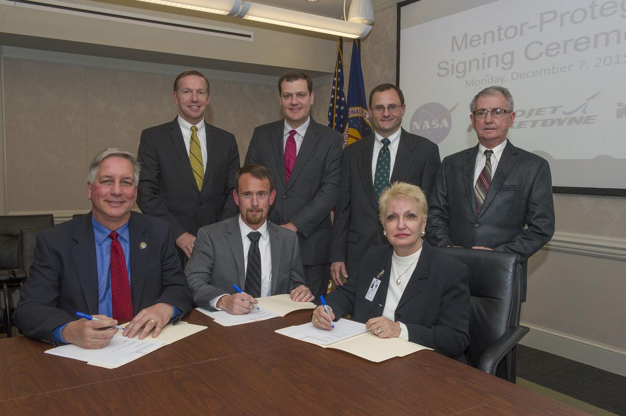 MENTOR PROTÉGÉ AGREEMENT SIGNING CEREMONY, DECEMBER 7, 2015  L TO R STANDING:  STEVE MILEY, TYLER COCHRAN, STEVE WOFFORD, DAVID BROCK (ALL NASA)  L TO R SEATED:  DANIEL ADAMSKI (AEROJET ROCKETDYNE), JOE MCCOLLISTER (NASA), EDWINA CIOFFI (ICO RALLY)