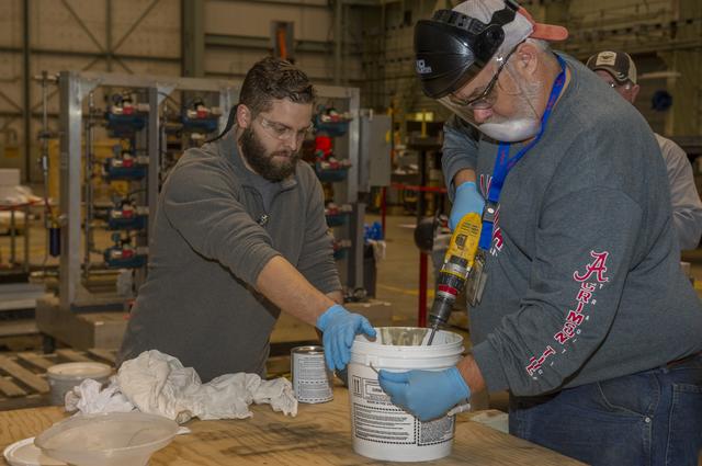 NASA image: TECHNICIANS MIX EPOXY