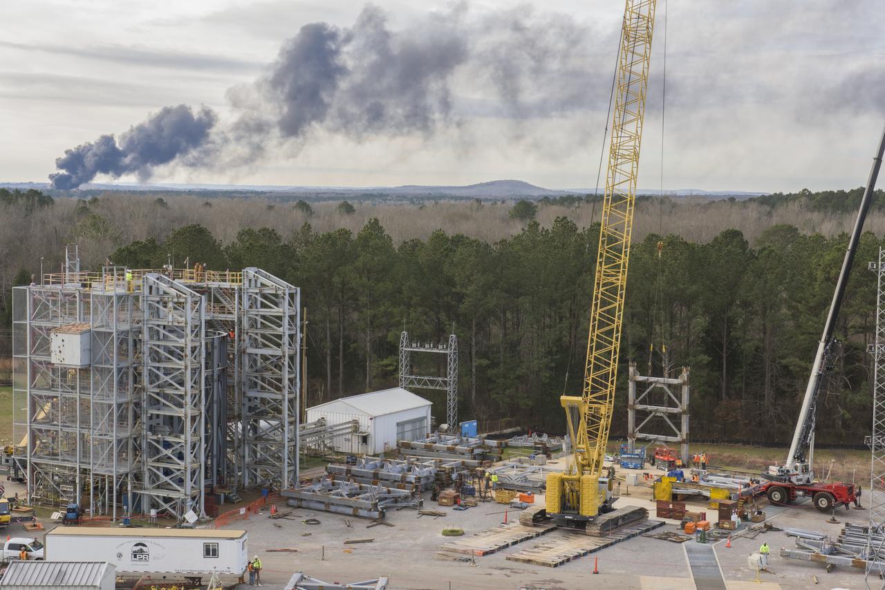 A CRANE MOVES THE FIRST STEEL TIER TO BE BOLTED INTO PLACE ON JAN. 6, FOR WELDING OF A SECOND NEW STRUCTURAL TEST STAND AT NASA'S MARSHALL SPACE FLIGHT CENTER IN HUNTSVILLE, ALABAMA -- CRITICAL TO DEVELOPMENT OF NASA'S SPACE LAUNCH SYSTEM. WHEN COMPLETED THIS SUMMER, THE 85-FOOT-TALL TEST STAND 4697 WILL USE HYDRAULIC CYLINDERS TO SUBJECT THE LIQUID OXYGEN TANK AND HARDWARE OF THE MASSIVE SLS CORE STAGE TO THE SAME LOADS AND STRESSES IT WILL ENDURE DURING A LAUNCH. THE STAND IS RISING IN MARSHALL'S WEST TEST AREA, WHERE WORK IS ALSO UNDERWAY ON THE 215-FOOT-TALL TOWERS OF TEST STAND 4693, WHICH WILL CONDUCT SIMILAR STRUCTURAL TESTS ON THE SLS CORE STAGE'S LIQUID HYDROGEN TANK. SLS, THE MOST POWERFUL ROCKET EVER BUILT, WILL CARRY ASTRONAUTS IN NASA'S ORION SPACECRAFT ON DEEP SPACE MISSIONS, INCLUDING THE JOURNEY TO MARS.