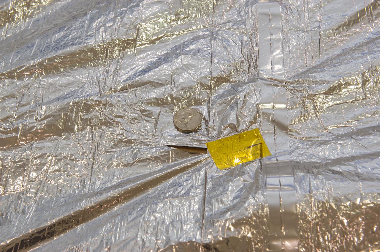 TIFFANY LOCKETT OVERSEES THE HALF SCALE (36 SQUARE METERS) ENGINEERING DEVELOPMENT UNIT (EDU) SOLAR SAIL DEPLOYMENT DEMONSTRATION IN PREPARATION FOR FULL SCALE EDU (86 SQUARE METERS) DEPLOYMENT IN APRIL, 2016. DETAILS OF RIPS AND HOLES IN SOLAR SAIL FABRIC.