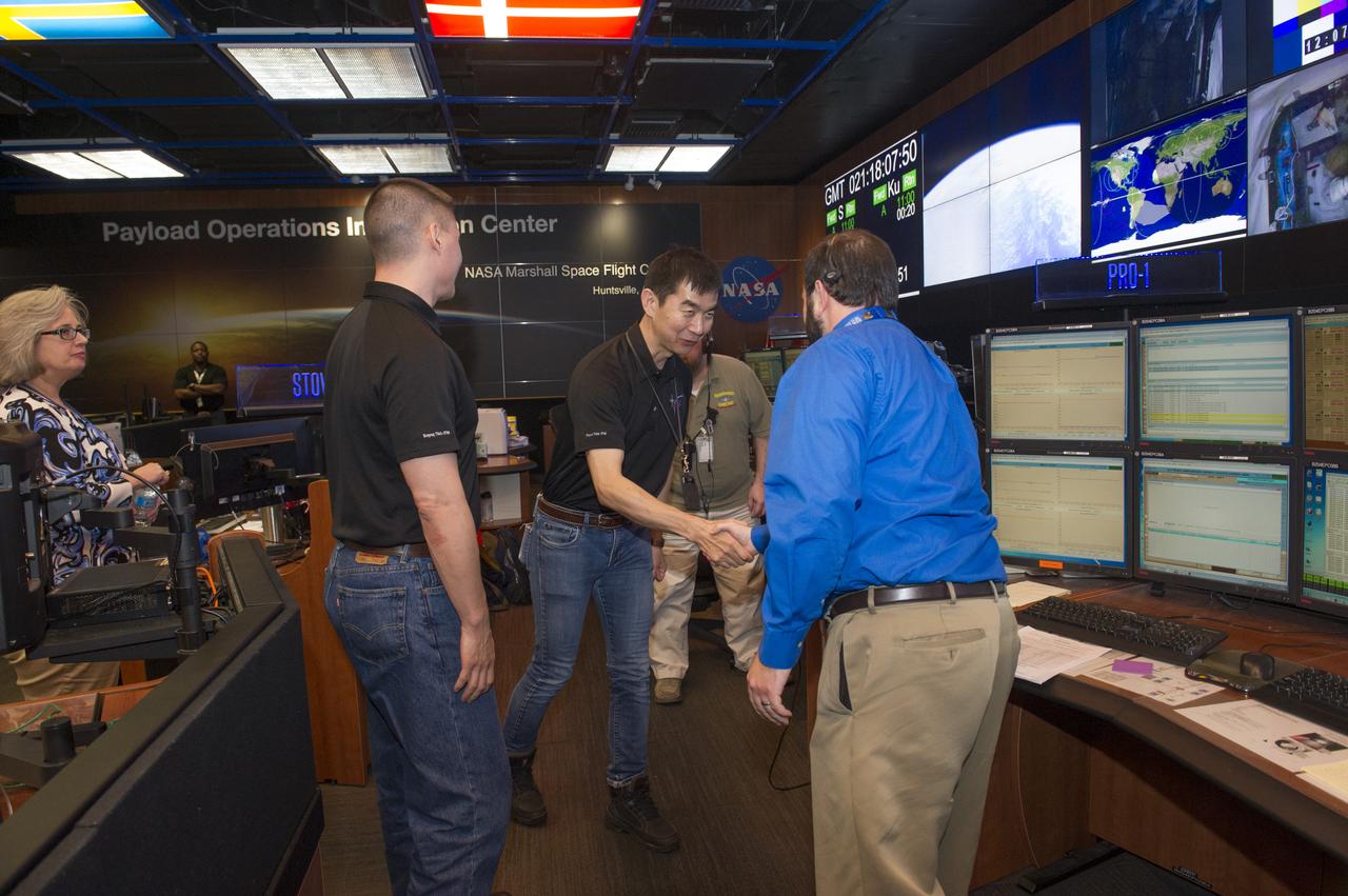 ASTRONAUT KIMIYA YUI SHAKES HANDS WITH PAYLOAD RACK OFFICER ROBERT TRIMBLE