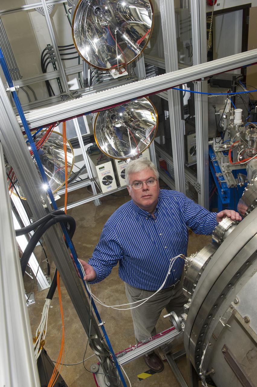 TODD SCHNEIDER LOOKS UP FROM WORK AT THE DOOR OF T HE HIGH INTENSITY SOLAR ENVIRONMENT TEST SYSTEM IN BUILDING 4605. SCHNEIDER IS A PHYSICIST IN THE MATERIALS AND PROCESSES DEPARTMENT AT MSFC AND IS PRINCIPAL INVESTIGATOR FOR HISET.