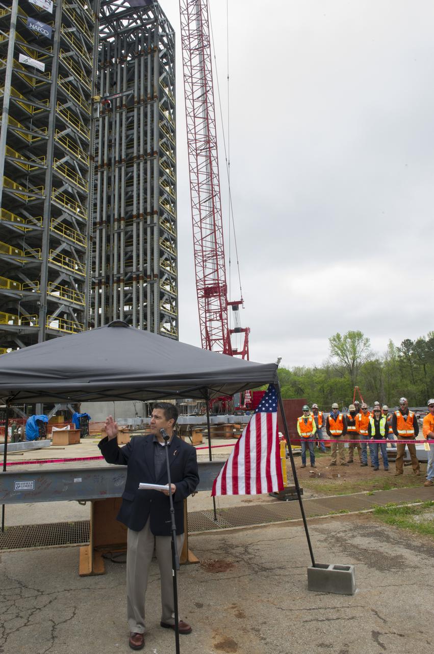 TIM FLORES SPEAKS TO THE CROWD IN FRONT OF A STEEL BEAM DESTINED FOR TEST STAND 4693 DURING THE STRUCTURE'S TOPPING OUT CEREMONY APRIL 12.