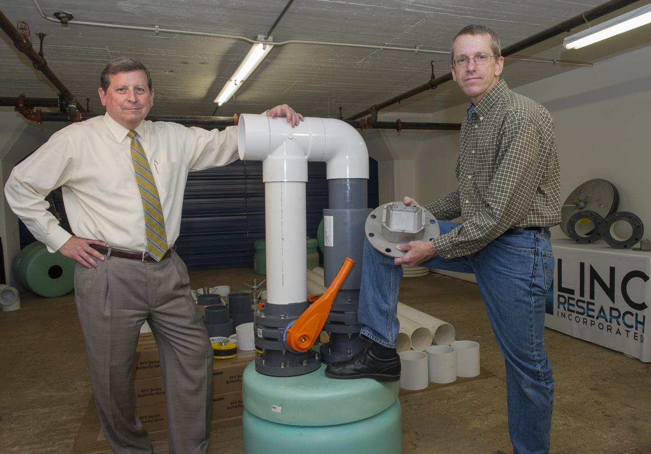CURTIS O. TAYLOR, PRESIDENT OF LINC RESEARCH CORP, (L), AND JEFF LINDNER, CHIEF ENGINEER, POSE WITH HARDWARE FOR THEIR PATENTED TECHNOLOGY, FLUID STRUCTURE COUPLING, WHICH USES SIMPLE PHYSICS TO DAMPEN POTENTIALLY HARMFUL SHAKING IN STRUCTURES. INSTALLATION OF THE FLUID STRUCTURE COUPLING TECHNOLOGY IN A BUILDING WILL TAKE PLACE IN SUMMER OF 2016.