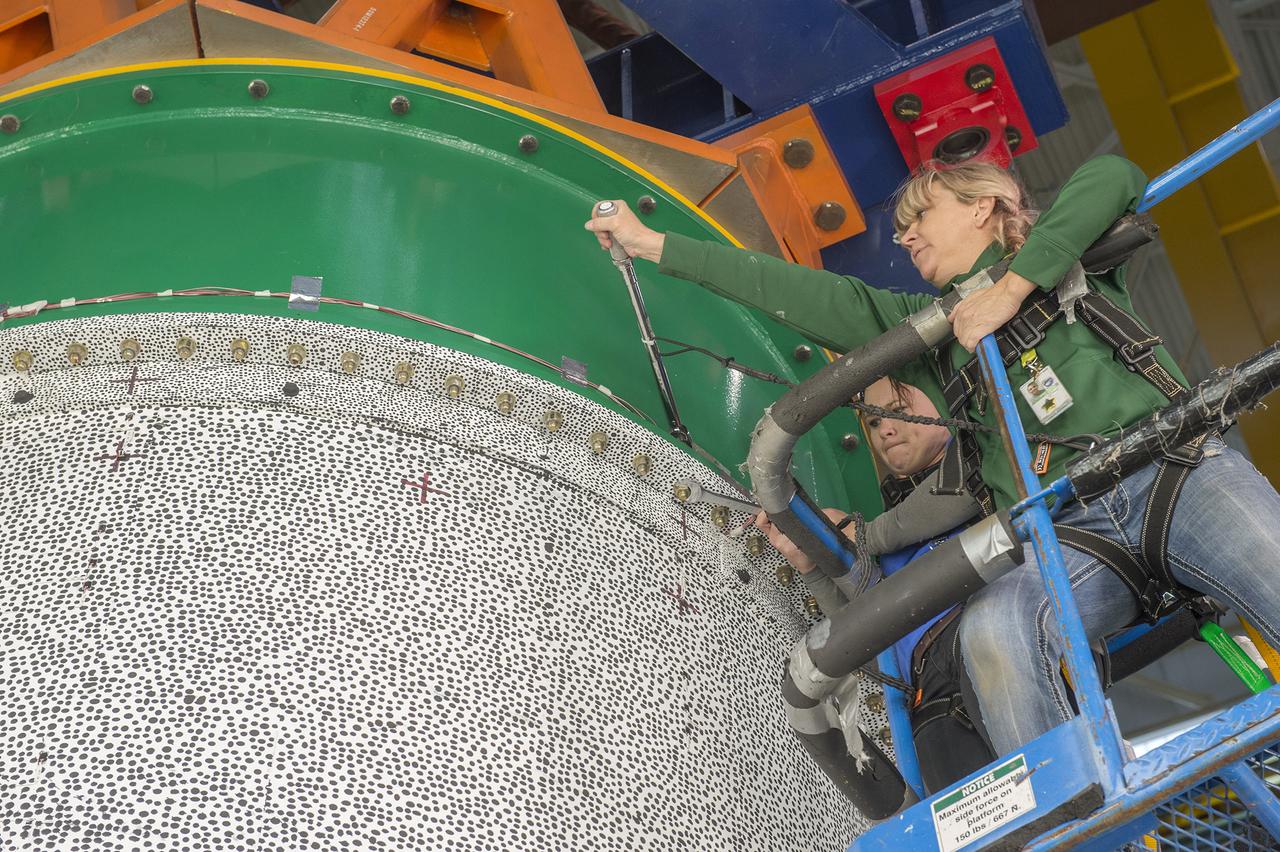 FROM RIGHT, KATHRYN GUELDE AND ASHLEY HOLLADAY OF AERIE AEROSPACE LLC IN HUNTSVILLE, INSTALL THE STRUCTURAL TEST ARTICLE FOR THE FIRST SERIES OF COMPOSITE TESTS FOR THE SHELL BUCKLING KNOCKDOWN FACTOR PROJECT.