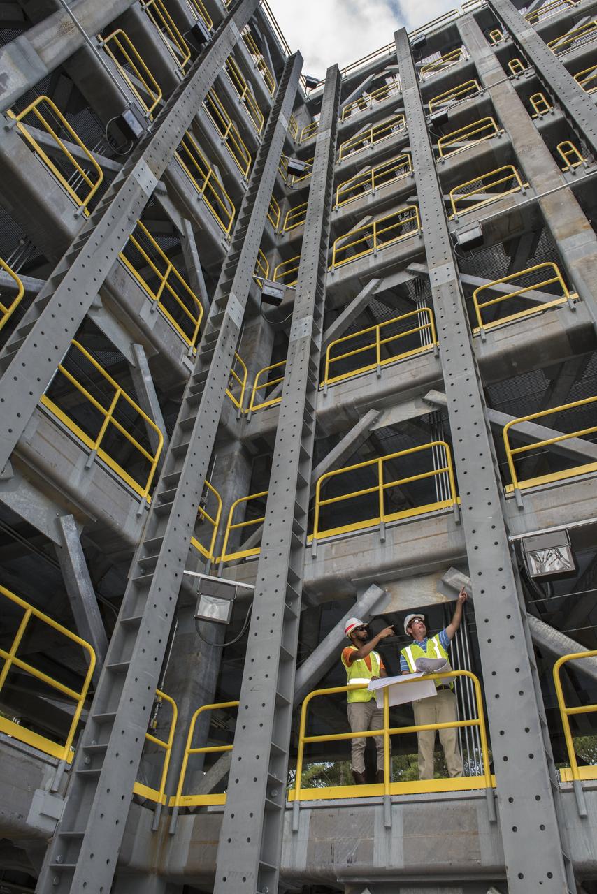 AS THE END OF CONSTRUCTION ON TEST STAND 4697, THE LIQUID OXYGEN TANK TEST STAND AT MARSHALL SPACE FLIGHT CENTER, PROJECT ENGINEERS PHIL HENDRIX, FROM MSFC, AND CURTNEY WALTERS FROM THE U.S. CORP OF ENGINEERS, STUDY PLANS AND PROGRESS.