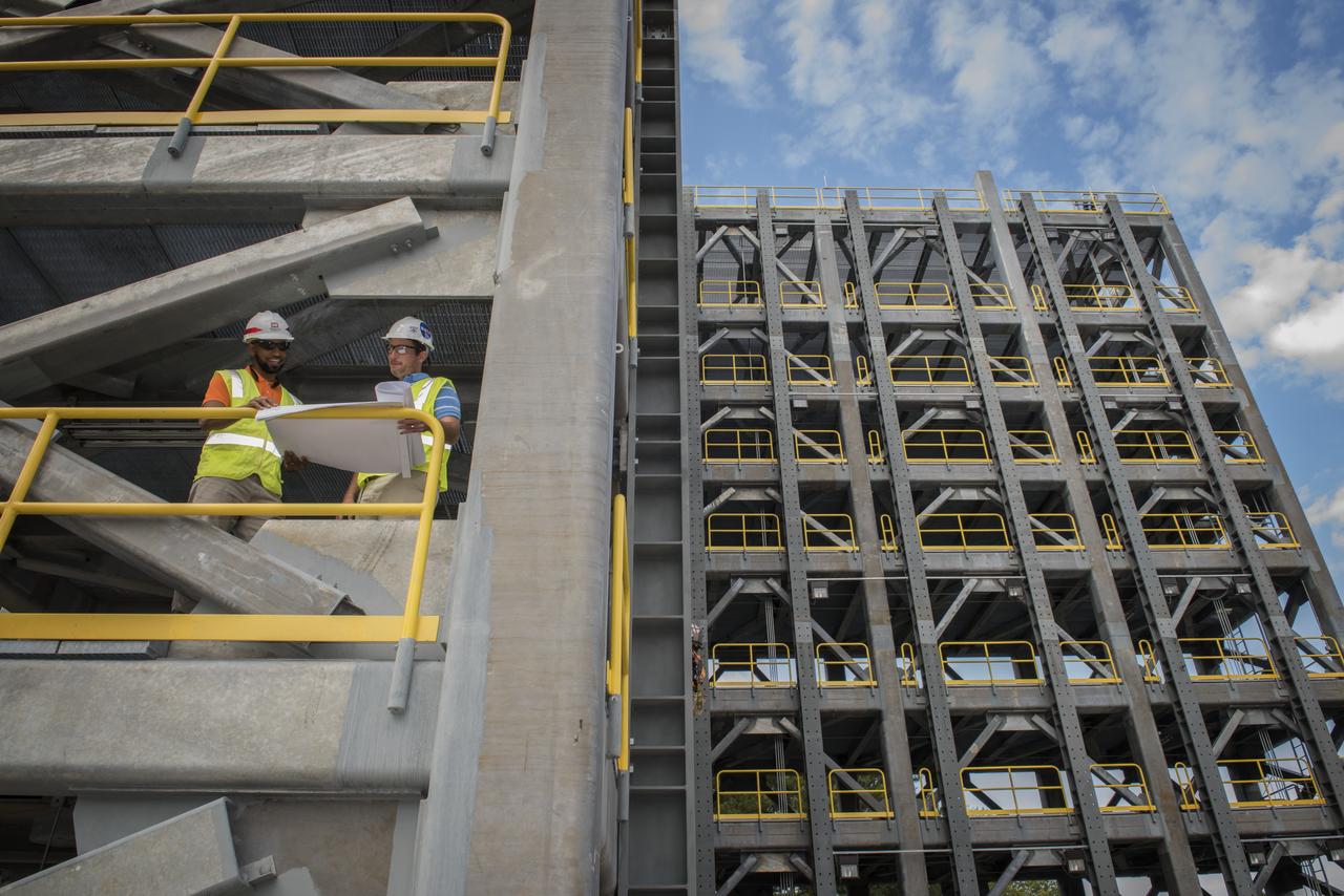 AS THE END OF CONSTRUCTION ON TEST STAND 4697, THE LIQUID OXYGEN TANK TEST STAND AT MARSHALL SPACE FLIGHT CENTER, PROJECT ENGINEERS PHIL HENDRIX, FROM MSFC, AND CURTNEY WALTERS FROM THE U.S. CORP OF ENGINEERS, STUDY PLANS AND PROGRESS.