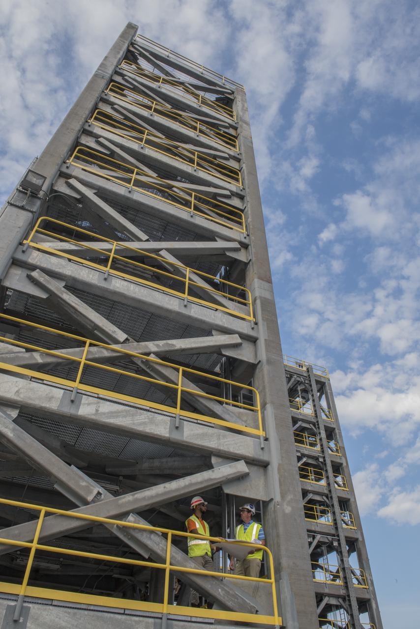 AS THE END OF CONSTRUCTION ON TEST STAND 4697, THE LIQUID OXYGEN TANK TEST STAND AT MARSHALL SPACE FLIGHT CENTER, PROJECT ENGINEERS PHIL HENDRIX, FROM MSFC, AND CURTNEY WALTERS FROM THE U.S. CORP OF ENGINEERS, STUDY PLANS AND PROGRESS.