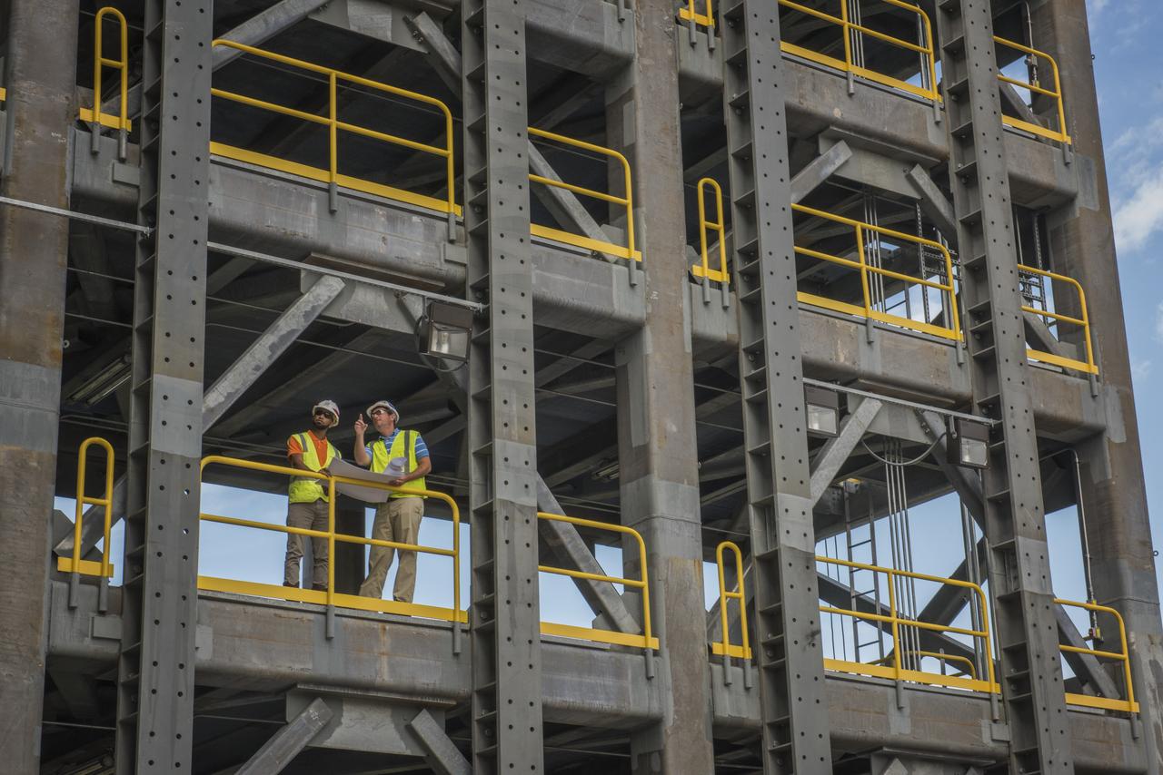 AS THE END OF CONSTRUCTION ON TEST STAND 4697, THE LIQUID OXYGEN TANK TEST STAND AT MARSHALL SPACE FLIGHT CENTER, PROJECT ENGINEERS PHIL HENDRIX, FROM MSFC, AND CURTNEY WALTERS FROM THE U.S. CORP OF ENGINEERS, STUDY PLANS AND PROGRESS.