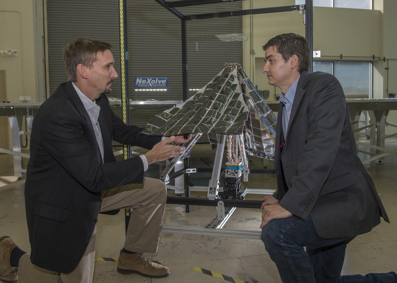 JOHN CARR, RIGHT, CO-PRINCIPAL INVESTIGATOR FOR NASA'S LIGHTWEIGHT INTEGRATED SOLAR ARRAY AND TRANSCEIVER PROJECT, TALKS WITH GREG LAUE, DIRECTOR OF AEROSPACE PRODUCTS FOR NEXOLVE, MANUFACTURER OF THE THIN-FILM TECHNOLOGY AND A PARTNER IN THE PROJECT.