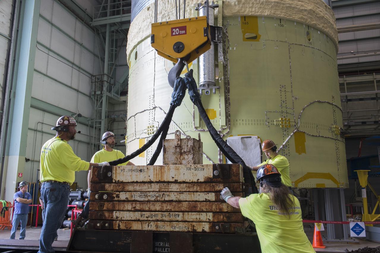 NASA engineers install test hardware for the agency's new heavy lift rocket, the Space Launch System, into a newly constructed 50-foot structural test stand at NASA's Marshall Space Flight Center. In the stand, hydraulic cylinders will be electronically controlled to push, pull, twist and bend the test article with millions of pounds of force. Engineers will record and analyze over 3,000 channels of data for each test case to verify the capabilities of the engine section and validate that the design and analysis models accurately predict the amount of loads the core stage can withstand during launch and ascent. The engine section, recently delivered via NASA's barge Pegasus from NASA's Michoud Assembly Facility, is the first of four core stage structural test articles scheduled to be delivered to Marshall for testing. The engine section, located at the bottom of SLS's massive core stage, will house the rocket's four RS-25 engines and be an attachment point for the two solid rocket boosters.