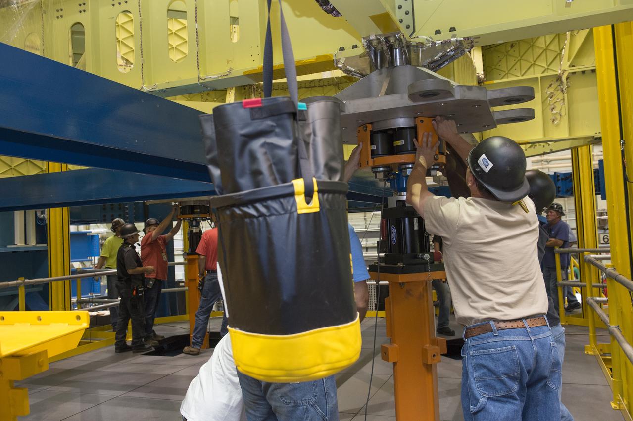 NASA engineers install test hardware for the agency's new heavy lift rocket, the Space Launch System, into a newly constructed 50-foot structural test stand at NASA's Marshall Space Flight Center. In the stand, hydraulic cylinders will be electronically controlled to push, pull, twist and bend the test article with millions of pounds of force. Engineers will record and analyze over 3,000 channels of data for each test case to verify the capabilities of the engine section and validate that the design and analysis models accurately predict the amount of loads the core stage can withstand during launch and ascent. The engine section, recently delivered via NASA's barge Pegasus from NASA's Michoud Assembly Facility, is the first of four core stage structural test articles scheduled to be delivered to Marshall for testing. The engine section, located at the bottom of SLS's massive core stage, will house the rocket's four RS-25 engines and be an attachment point for the two solid rocket boosters.