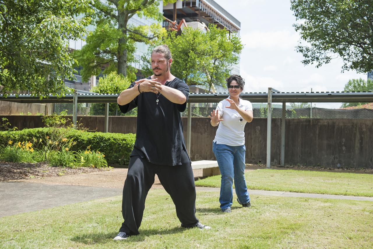 Warren Cain, an instructor at WuDang Martial Arts Center in Huntsville, leads Marshall Pathways intern Donna Cendana of the Engineering Directorate's Propulsion Systems Department, in a demonstration of tai chi, the noncompetitive Eastern martial arts tradition that evolved over the centuries into a means of alleviating stress and anxiety.