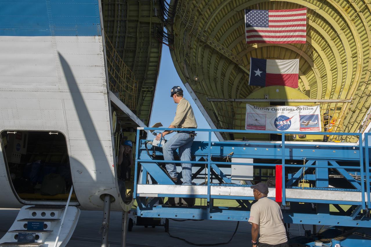 The platform which will be used to load the Orion stage adapter is being positioned in front of the cargo bay of NASA's Super Guppie aircraft. The adapter is being flown to Denver, Colorado for further testing.