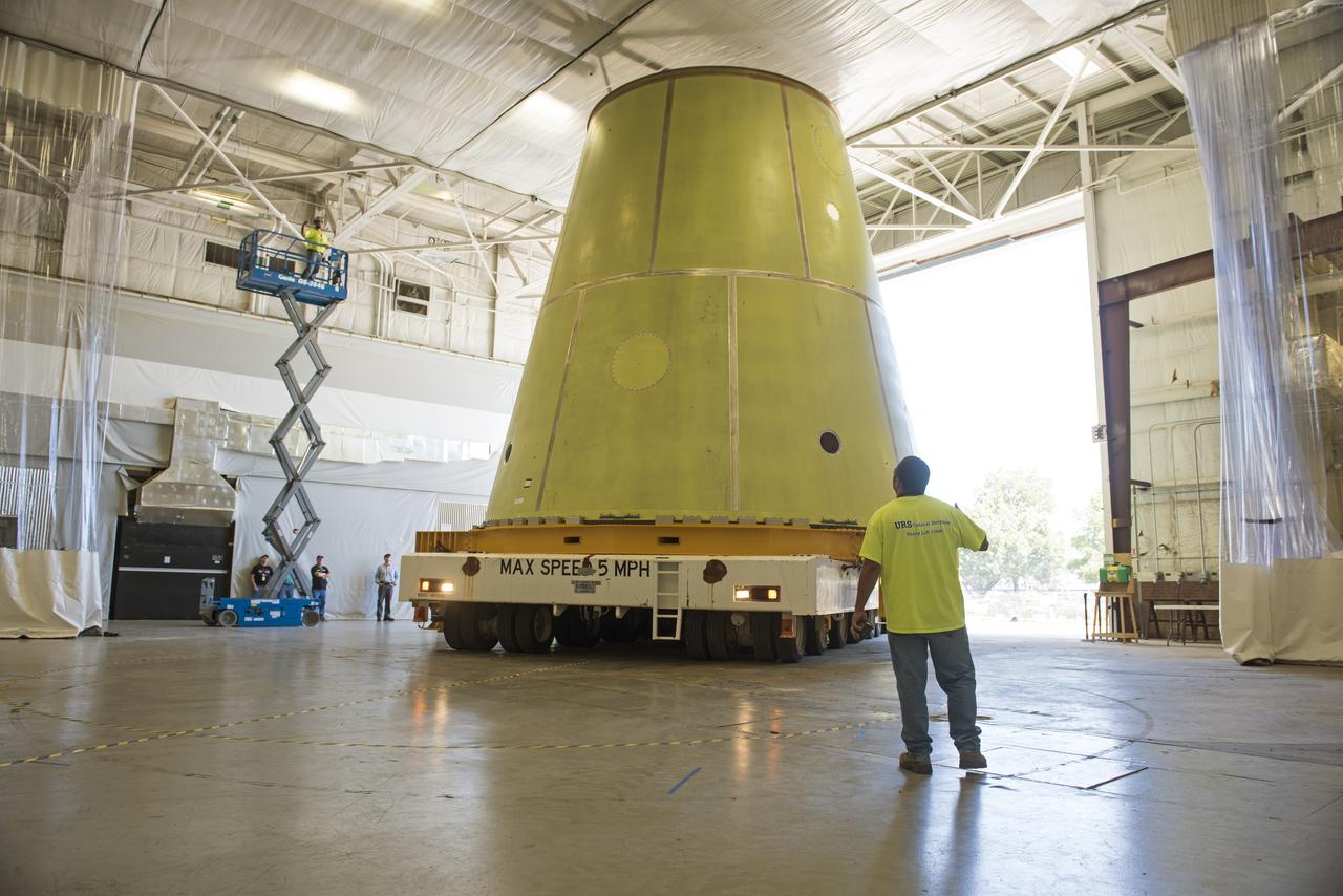A NASA KAMAG transporter moves the Space Launch System’s launch vehicle stage adapter (LVSA) to an area where spray-on foam insulation will be applied. The LVSA recently completed manufacturing on a 30 foot welding tool at NASA’s Marshall Space Flight Center in Huntsville, Al. The LVSA will be coated with insulation that will protect it during it’s trip to space. The LVSA provides structural support and connects the core stage and the interim cryogenic propulsion stage during the first integrated flight of SLS and Orion.