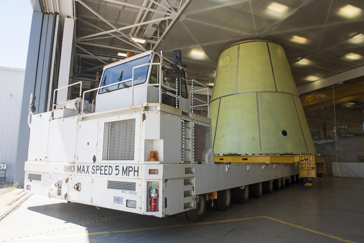 A NASA KAMAG transporter moves the Space Launch System’s launch vehicle stage adapter (LVSA) to an area where spray-on foam insulation will be applied. The LVSA recently completed manufacturing on a 30 foot welding tool at NASA’s Marshall Space Flight Center in Huntsville, Al. The LVSA will be coated with insulation that will protect it during it’s trip to space. The LVSA provides structural support and connects the core stage and the interim cryogenic propulsion stage during the first integrated flight of SLS and Orion.