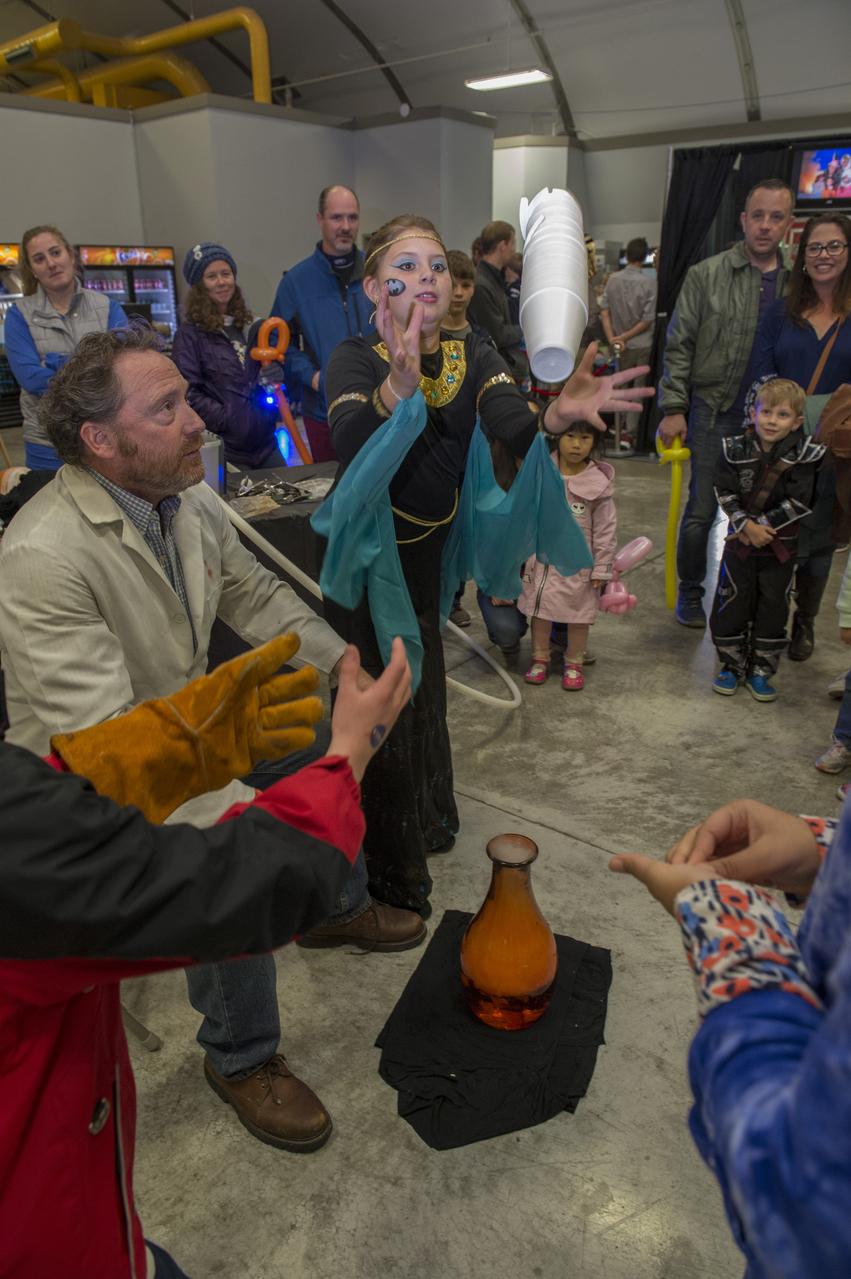 A volunteer assists an eager participant at International Observe the Moon Night Oct. 28 at the U.S. Space & Rocket Center. The event, hosted by the Planetary Missions Program at NASA's Marshall Space Flight Center, encourages observation and appreciation of the Moon and its connection to NASA planetary science and exploration, as well as our cultural and personal connections to it. Children attending the event had the opportunity to participate in planetary, science-based, hands-on activities