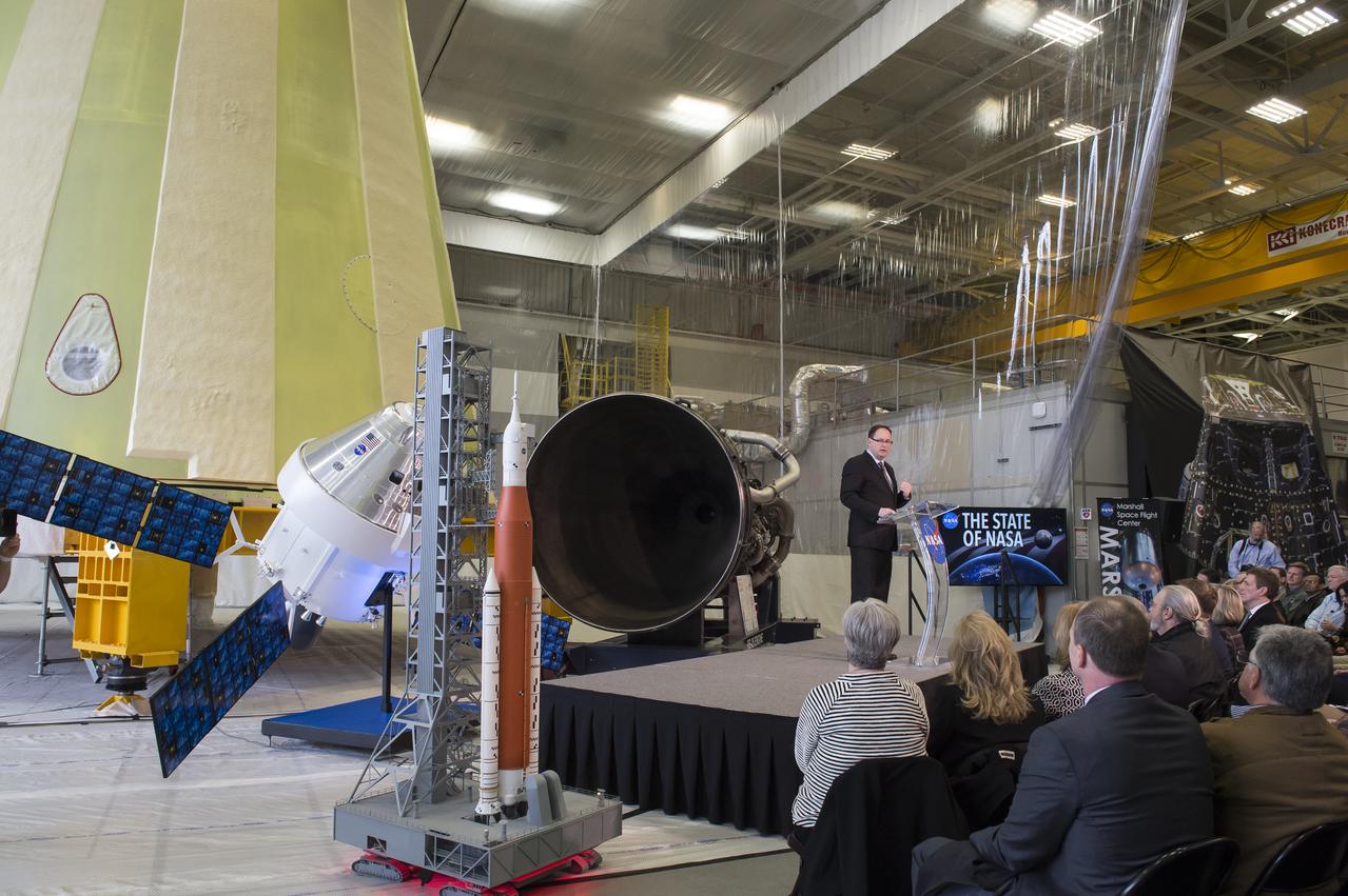 NASA Acting Administrator Robert Lightfoot delivers the "State of NASA", February 12, 2018, at the Marshall Space Flight Center in Huntsville, Alabama. In his address, Lightfoot discussed what the President's Fiscal Year 2019 budget request means for America's space agency. According to Lightfoot, it "reflects the administration's confidence that America will lead the way back to the Moon and take the next giant leap". Lightfoot delivered the "State of NASA" address in Marshall's Center for Advanced Manufacturing where engineers are pushing boundaries in the fields of additive manufacturing, 3D printing, and more. Hardware for NASA's Space Launch System and a model of the agency's Orion spacecraft served as a backdrop for the annual event. SLS, which is managed by Marshall, will enable a new era of exploration beyond Earth's orbit by launching astronauts on missions to deep-space destinations including the Moon and Mars.
