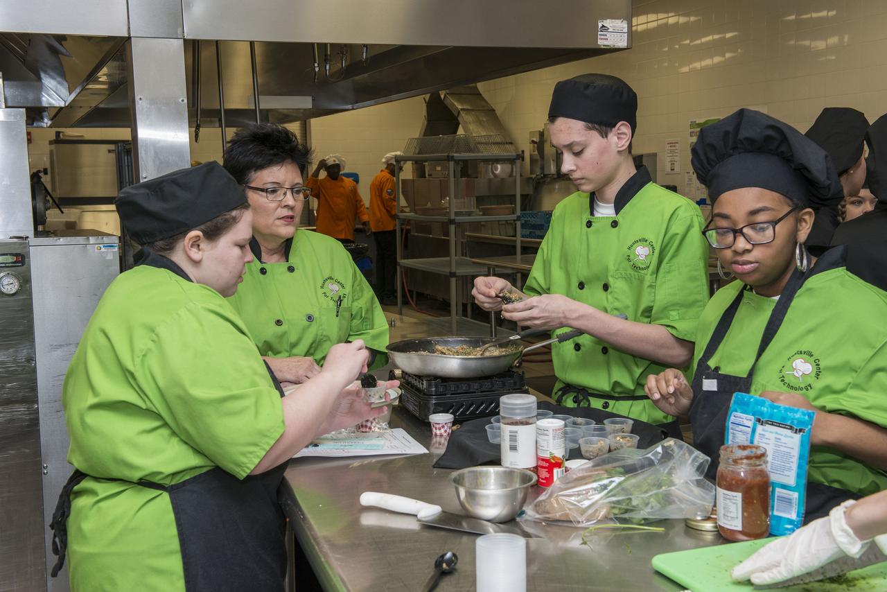 High Schools United with NASA to Create Hardware (HUNCH) students from 6 schools meet at the U.S. Space and Rocket center in order to participate in the annual culinary challenge where students create meals suitable for astronaut use in space. Students in 2018 created different dishes for breakfast dining. Other NASA centers also participate in this program with the top 10 voted recipes being judged at Johnson Space Center.