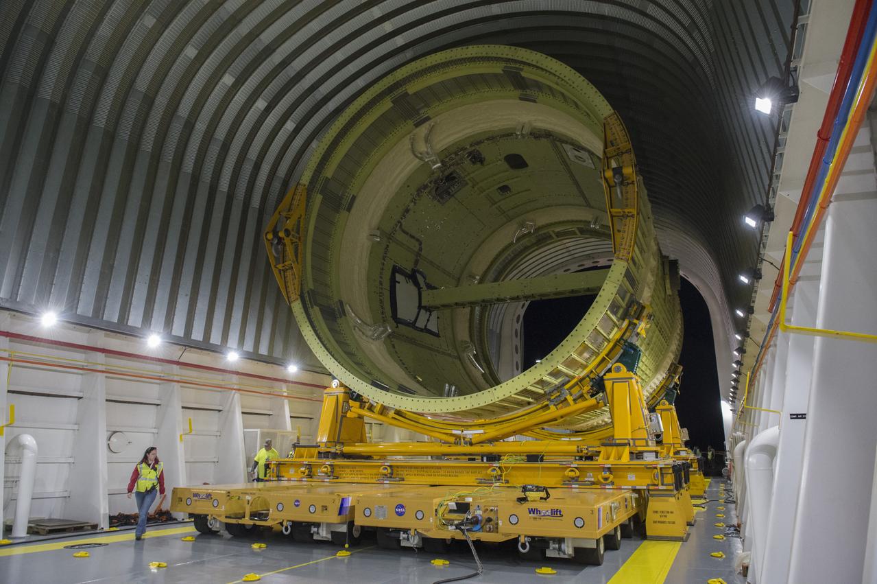 The SLS Stages Intertank Structural Test Assembly (STA) is rolling off the NASA Pegasus Barge at the MSFC Dock enroute to the MSFC 4619 Load Test Annex test facility for qualification testing