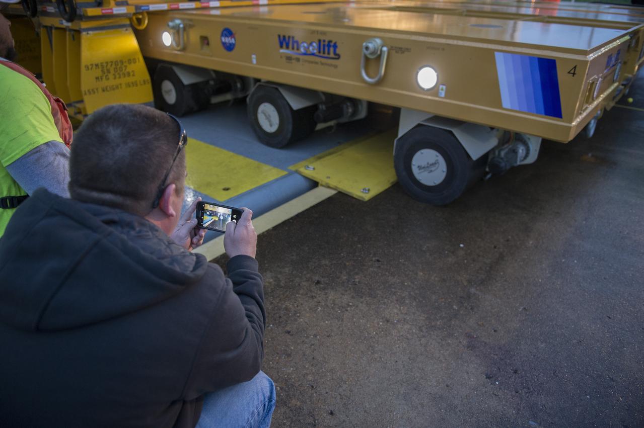 The SLS Stages Intertank Structural Test Assembly (STA) is rolling off the NASA Pegasus Barge at the MSFC Dock enroute to the MSFC 4619 Load Test Annex test facility for qualification testing